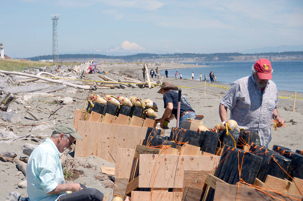 Bob Frampton, left, Bill Stabile, right, and head pyrotechnician David Chuljian, back, set up a fireworks display on the beach at Fort Worden for the third annual Old School 4th of July celebration. (Cydney McFarland/Peninsula Daily News)