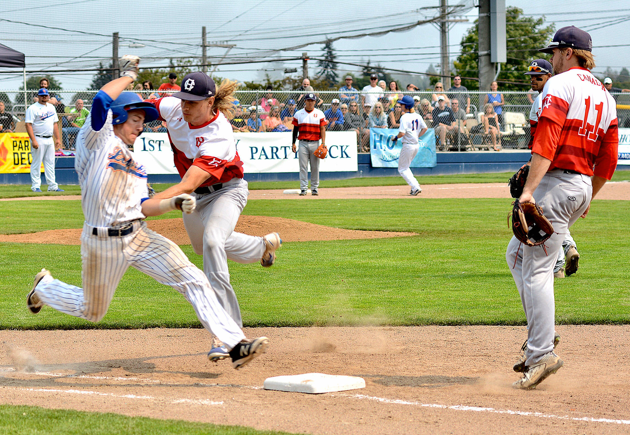 Lefties’ second baseman Bryan Hill is tagged out by HarbourCats’ pitcher Radd Thomas in Sunday’s final game of the season at Civic Field. (Jay Cline/for Peninsula Daily News)