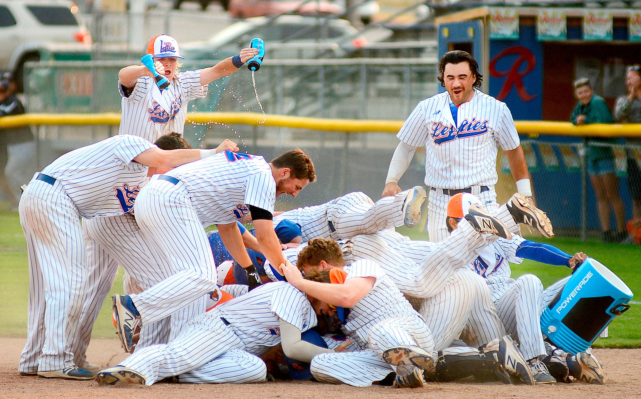 The Port Angeles Lefties celebrate an 11th-inning walkoff 17-16 win over the Victoria HarbourCats Sunday. The game took 5 hours to play and the two teams combined for 38 hits and 24 walks. (Jay Cline/for Peninsula Daily News)