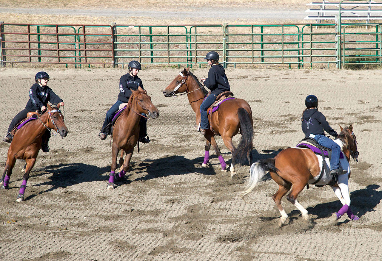 The Silver Spurs Drill Team performs a routine during opening day of the Jefferson County Fair in Port Townsend last year. The team, all from Port Townsend are, in no particular order, Rachel Doan, Kathryn McKenny, Jaden Schmidt and Karley Caseser. (Steve Mullensky/for Peninsula Daily News)