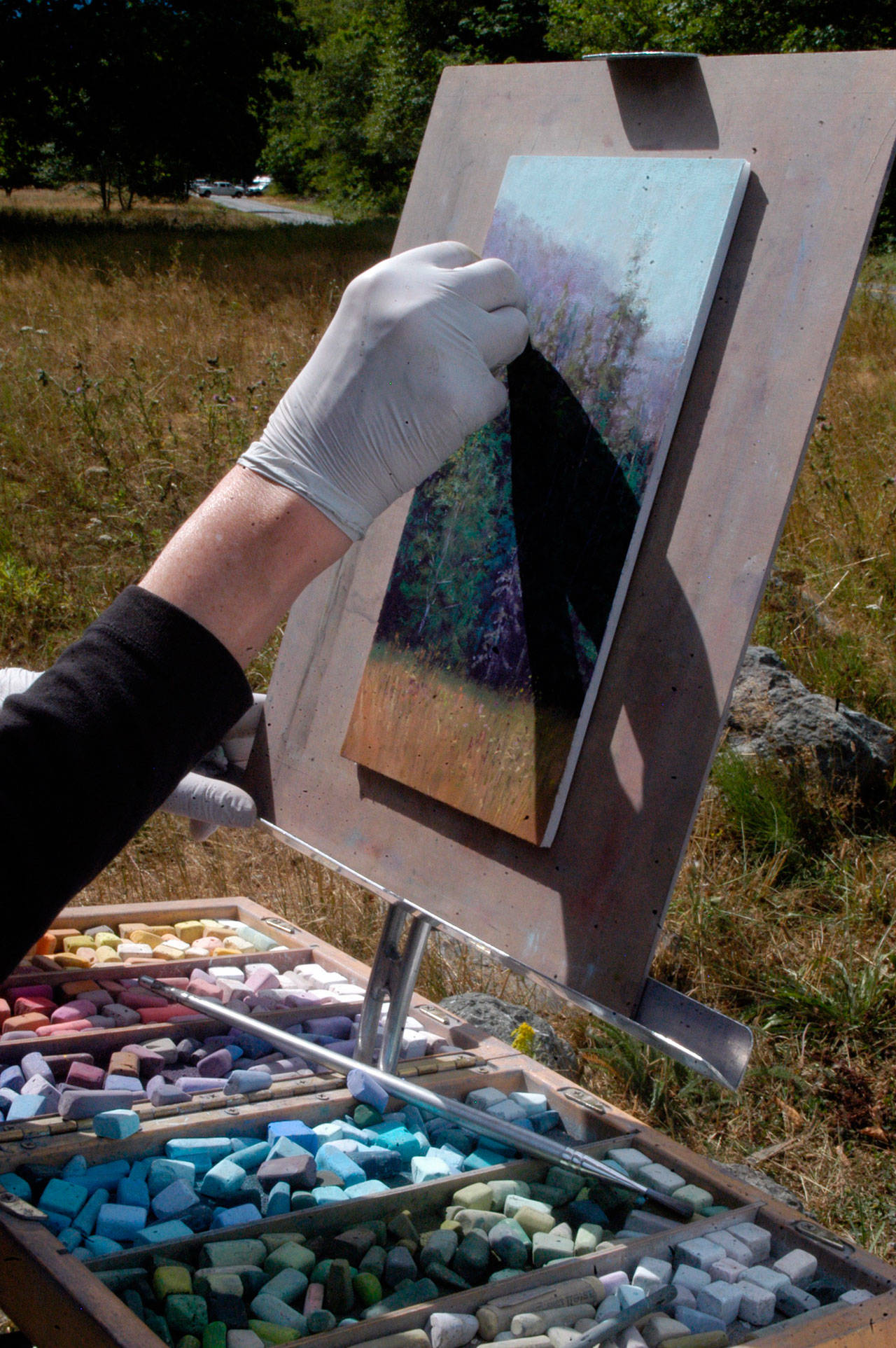 Gretha Lindwood adds the finishing touches to her 6-inch-by-11-inch landscape painting for Paint the Peninsula on Wednesday. (Sarah Sharp/Peninsula Daily News)