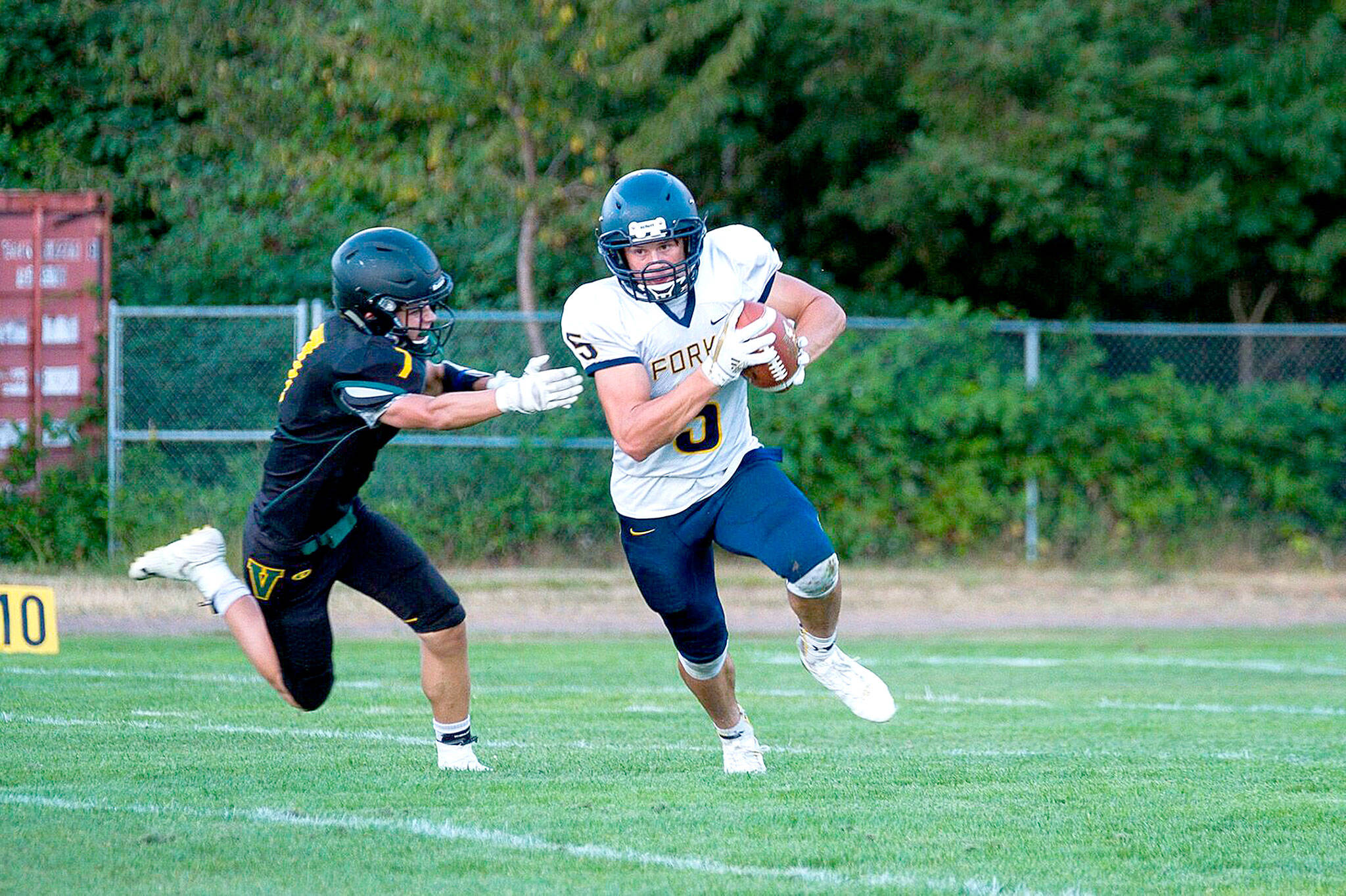 Forks’ Cole Baysinger runs from a Vashon defender during the Spartans’ 68-0 win Friday. (Kent Phelan/Vashon Beachcomber)