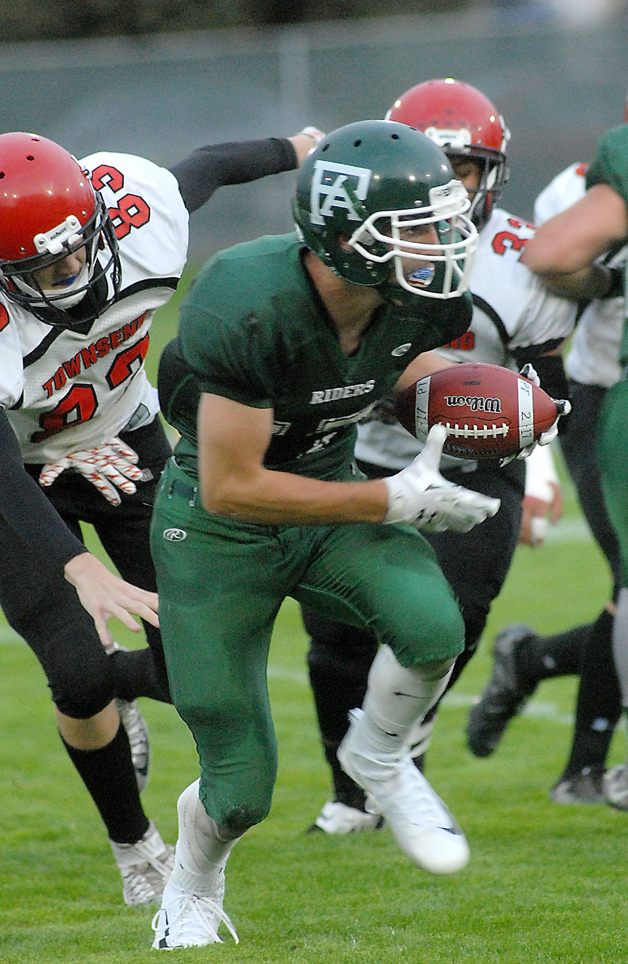 Port Angeles’ Garrett Edwards, center, carries the ball while avoiding the defense of Port Townsend’s Jaden Steinfort, left, and Jacob Boucher, rear, during the first quarter on Friday at Port Angeles Civic Field. Keith Thorpe/Peninsula Daily News