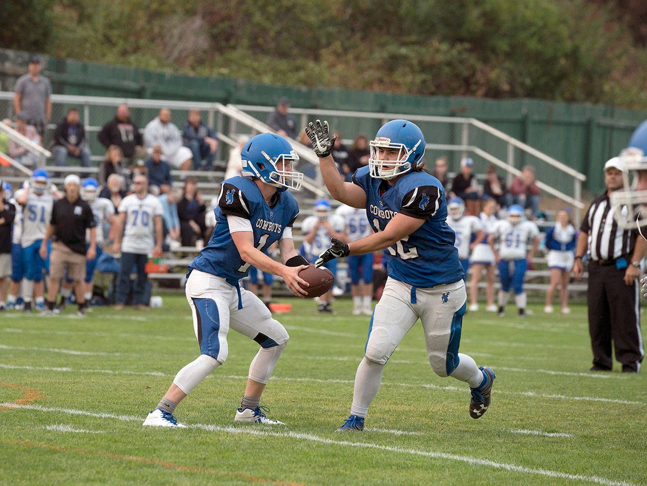 Steve Mullensky/for Peninsula Daily News                                Chimacum quarterback Peyton Hudley, left, hands off to Logan Storm during the Cowboys’ 13-6 win over South Whidbey.