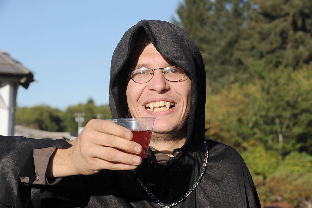 Kameron Goggins tastes red juice representing vampire blood at the Forks Visitors Center during Twilight events. (Lonnie Archibald/for Peninsula Daily News)