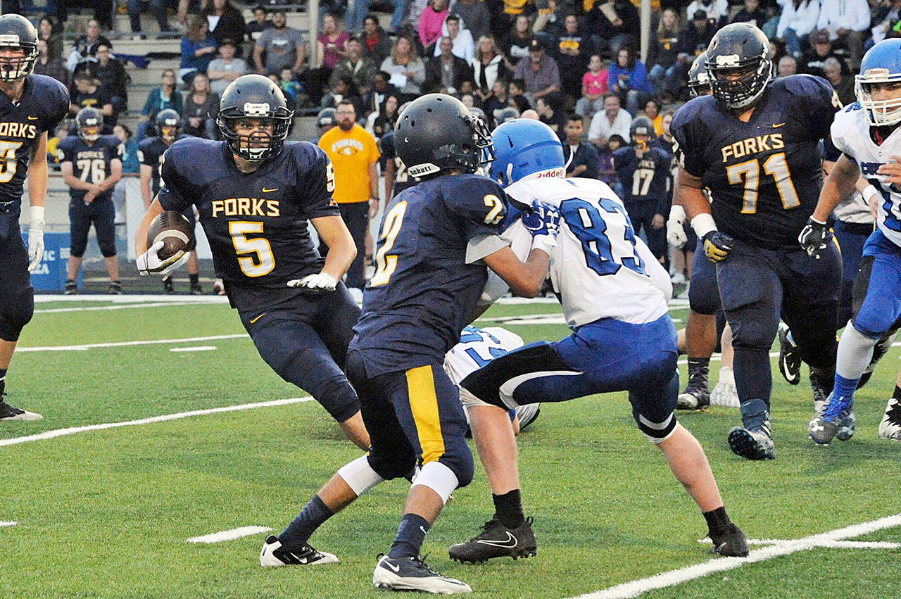 Lonnie Archibald/for Peninsula Daily News Forks’ Cole Baysinger (5) cuts back for a big gain against Chimacum on Friday at Spartan Stadium. Baysinger racked up 352 yards and 5 touchdowns on 20 carries. Blocking for Baysinger is Tony Hernandez-Flores against Chimacum’s Issac Purser.
