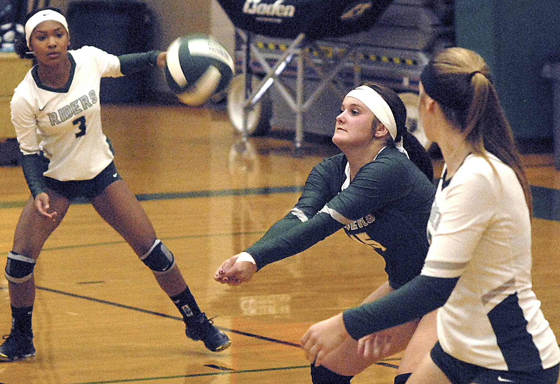Keith Thorpe/Peninsula Daily News Port Angeles’ Brennan Gray, center, sets the ball as teammates Lannie Lyamba, left, and Devin Edwards look on in the second game of Tuesday night’s match against Bremerton at Port Angeles High School.