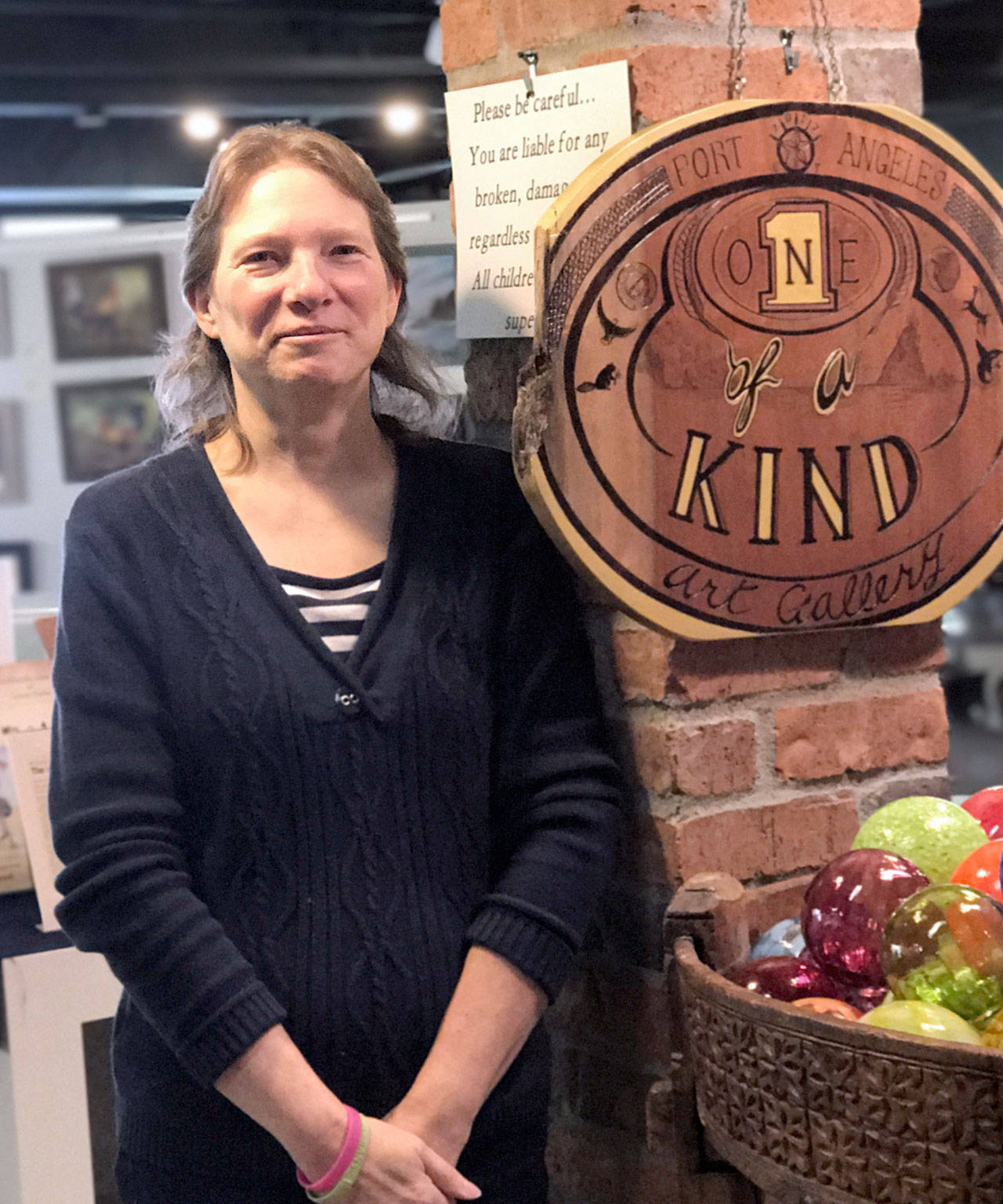 Mary Comeau poses in her new art gallery, 1 of A Kind, in The Landing mall where Heatherton Gallery resided before the owners, Sky Heatherton and Thomas East, retired in August. (Mary Comeau)