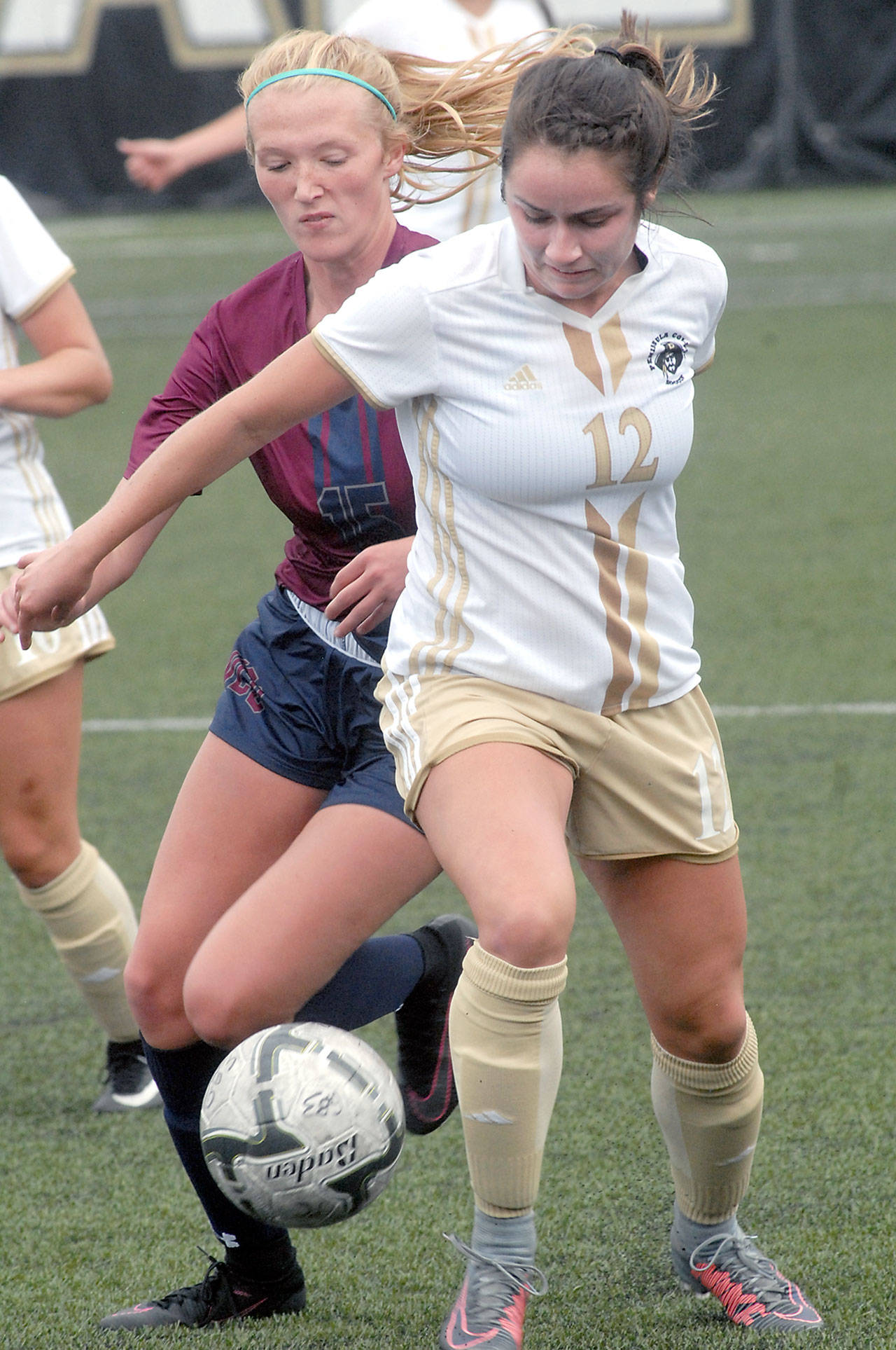 Peninsula’s Malia Brudvik, front, and Whatcom’s Payton Lunde battle for the ball in the first half on Wednesday in Port Angeles. Keith Thorpe/Peninsula Daily News