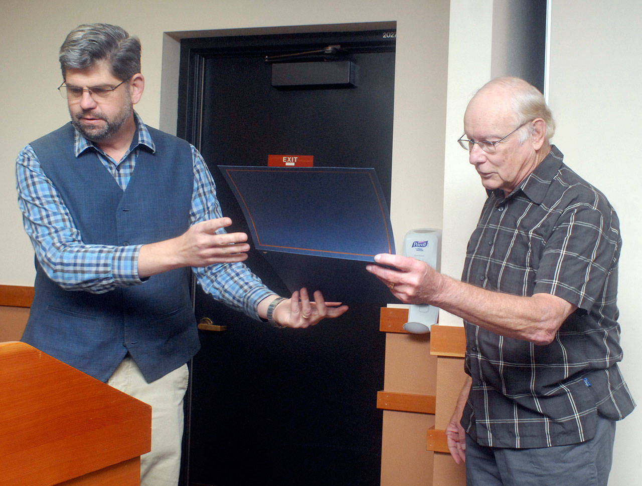 Clallam County Commissioner Mark Ozias, left, presents a certificate of appreciation to retiring County Public Works Director Bob Martin during Tuesday’s commissioners’ meeting in Port Angeles. (Keith Thorpe/Peninsula Daily News)