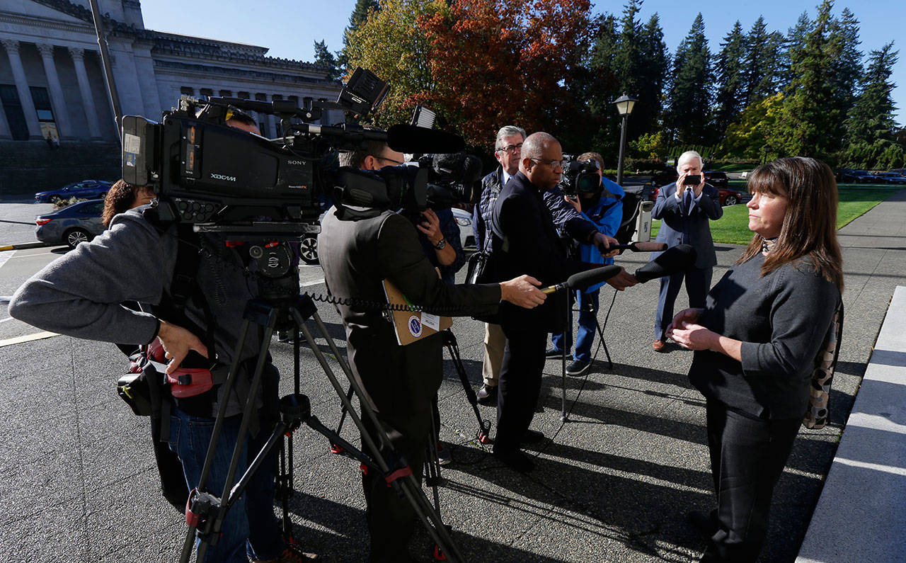 Stephanie McCleary of Chimacum, right, one of the plaintiffs in a lawsuit against the state of Washington regarding the funding of education, talks to reporters Tuesday after she attended arguments in a state Supreme Court hearing in Olympia to determine whether the state has fulfilled its constitutional duty to fully fund basic education. (Ted S. Warren/The Associated Press)