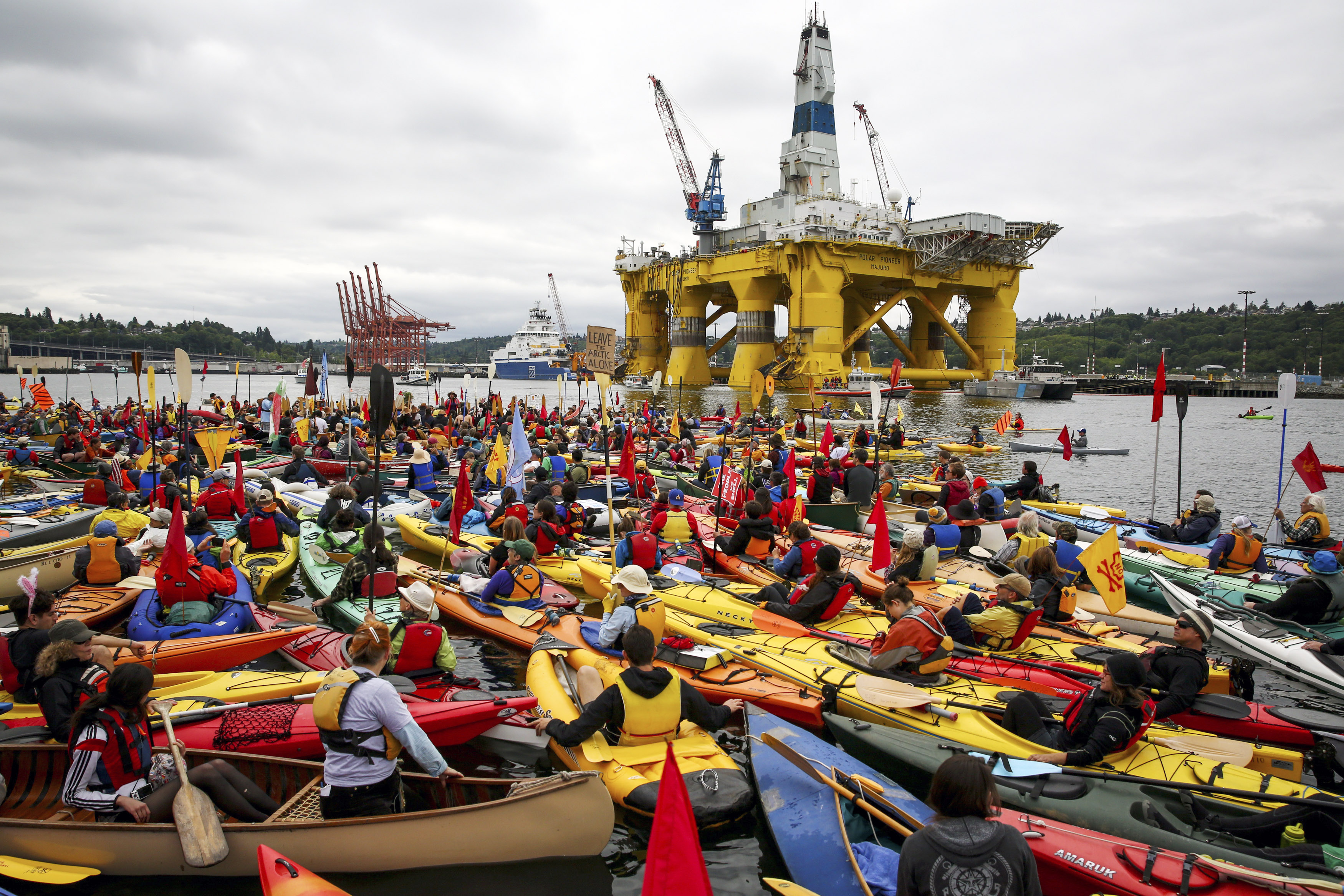 Activists in kayaks and other vessels who oppose Royal Dutch Shell's plans to drill for oil in the Arctic Ocean mass near Shell's Polar Pioneer drilling rig in Seattle's Elliott Bay on Saturday. (The Associated Press (CLICK on photo to enlarge))