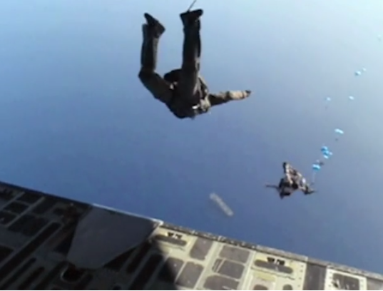 Members of SEAL Team 6 and other units parachute from a plane near the frigate U.S.S. Halyburton