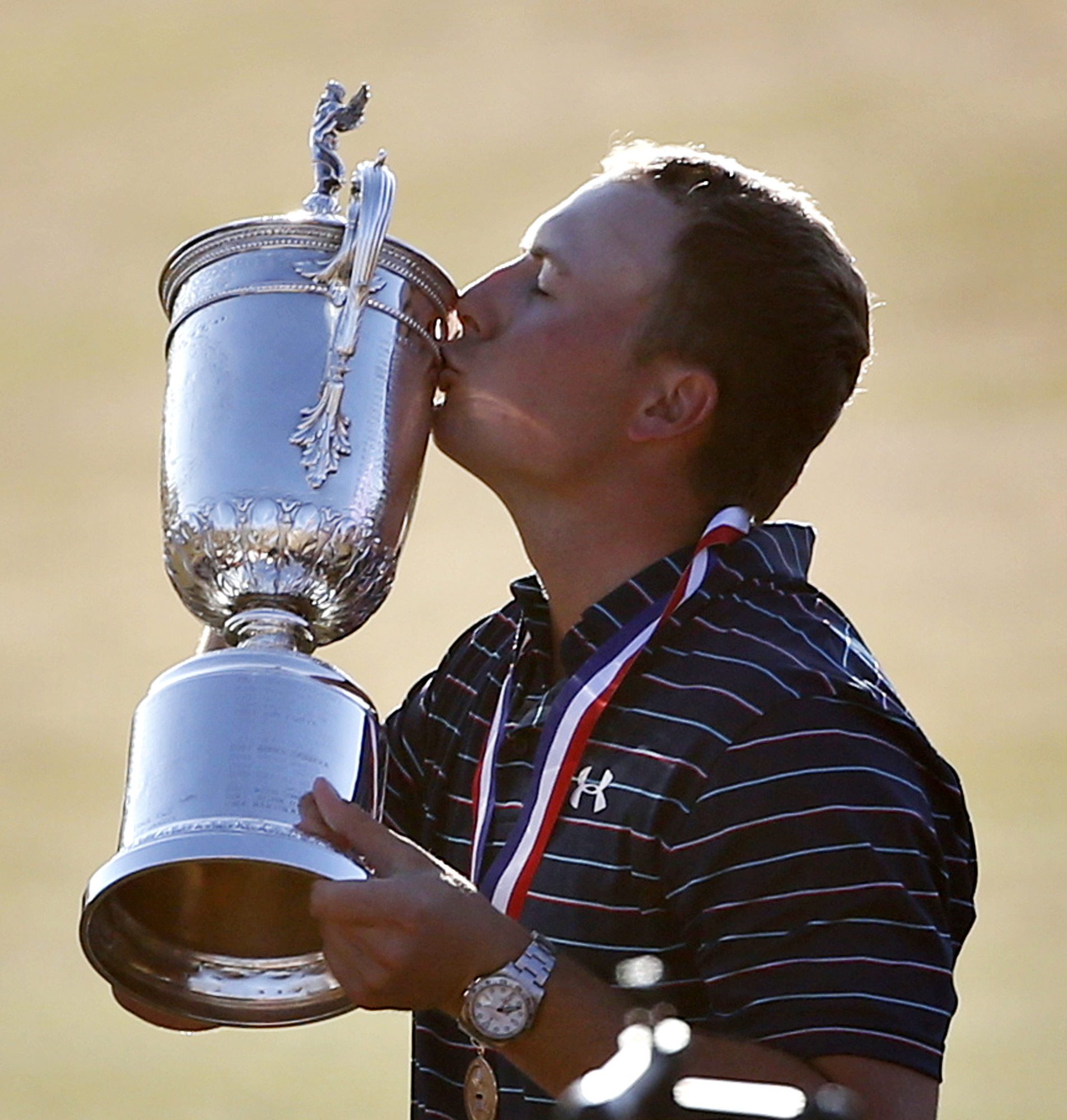 Jordan Spieth kisses the trophy after winning the the U.S. Open golf tournament at Chambers Bay on Sunday in University Place. (The Associated Press)