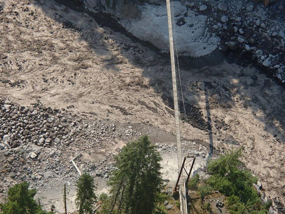 A torrent of water and debris from a glacial outburst Thursday flows under a suspension bridge near Indian Henry's Hunting Ground at Mount Rainier National Park. National Park Service (Click on image to enlarge)