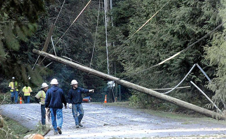 Clallam County Public Utility District No. 1 workers examine a downed power pole along Black Diamond Road near Westridge Road south of Port Angeles on Friday morning. (Keith Thorpe/Peninsula Daily News)