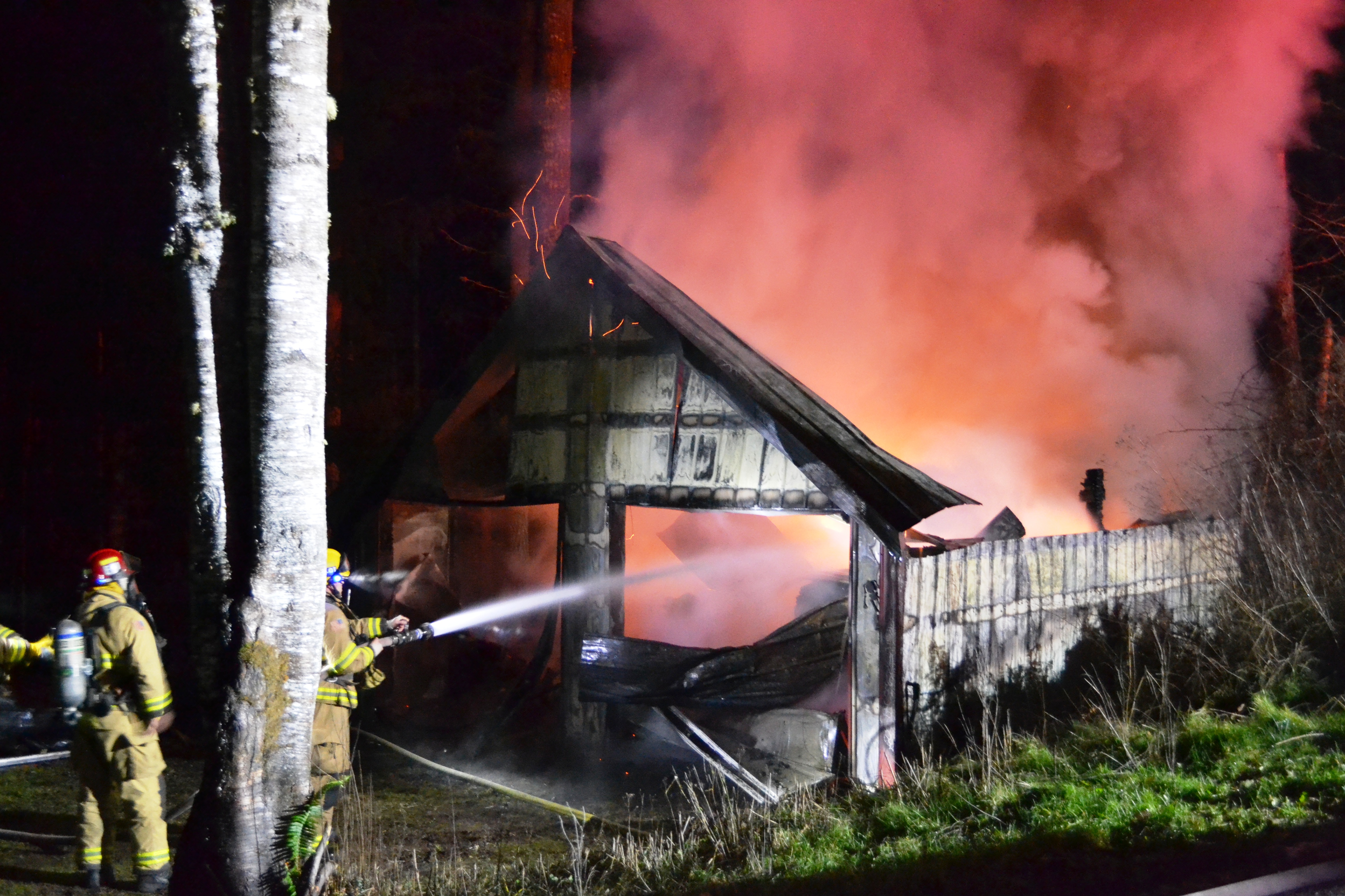 East Jefferson Fire-Rescue firefighters attempt to put out the blaze in a detached garage Saturday evening in the 600 block of Crutcher Road near Port Townsend. (Bill Beezley/East Jefferson Fire-Rescue)