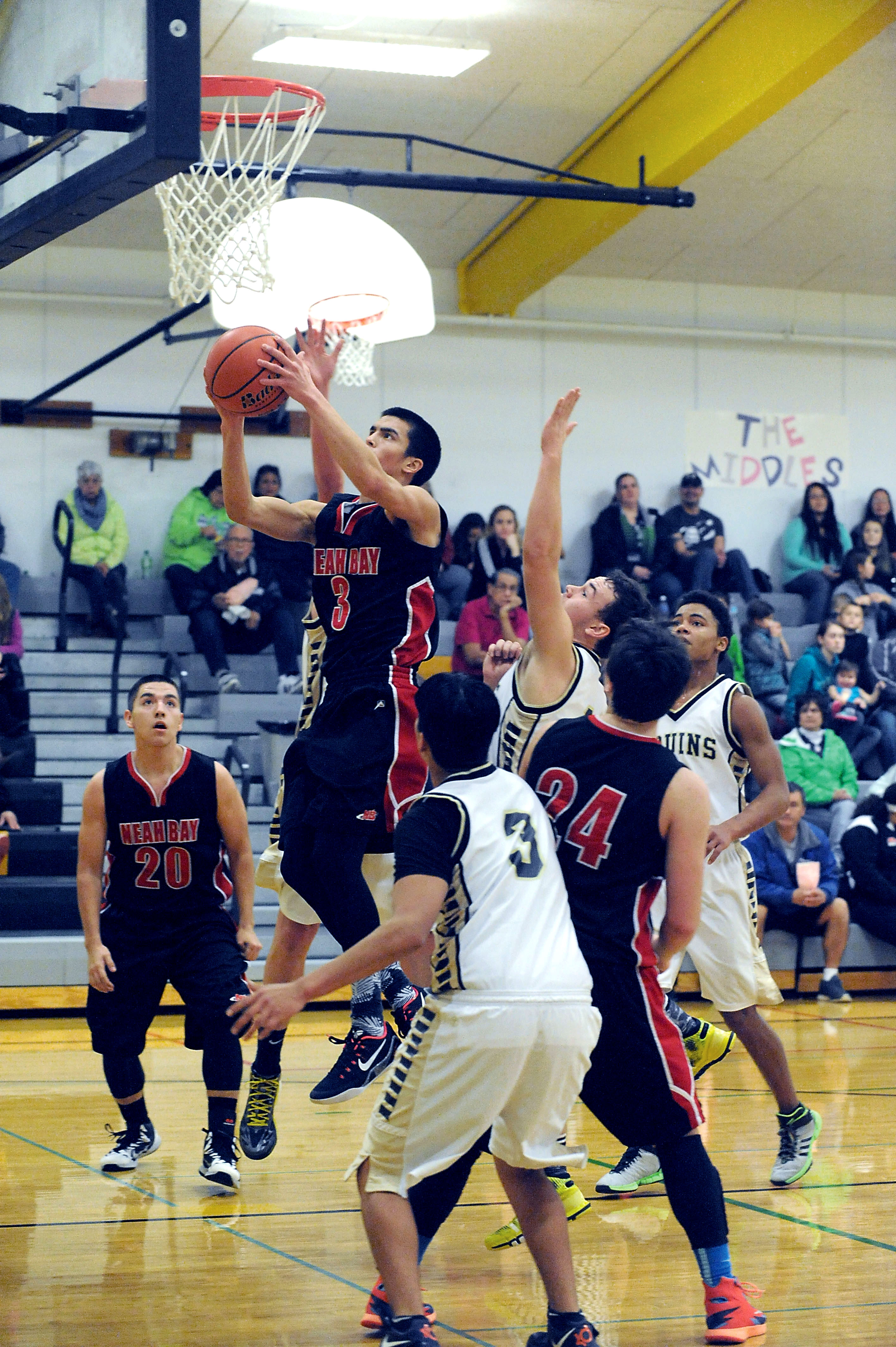 Neah Bay's Abraham Venske (3) puts up a shot against the defense of Clallam Bay's Kelly Gregory and Alan Greene (3) while Neah Bay's Ryan Moss (24) prepares to block out. Also in on the play are Neah Bay's Jongi Claplanhoo (20) and Clallam Bay's Sam Signor