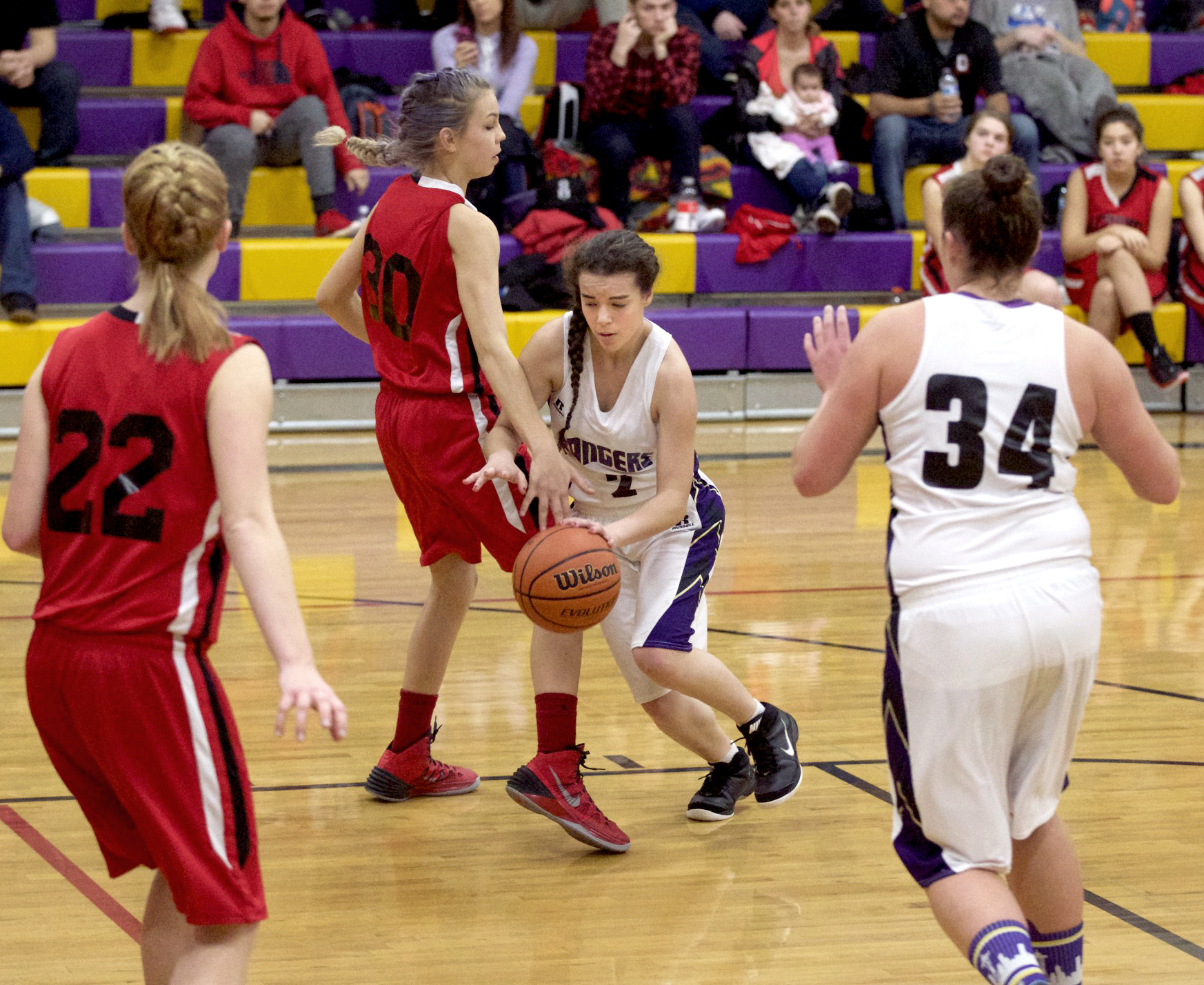 Quilcene's Hanna Williams (2) drives into the defense of Oakville's Kelsey Bray (22) as Williams' teammate Sammy Rae (34) closes in on the play. (Steve Mullensky/for Peninsula Daily News)