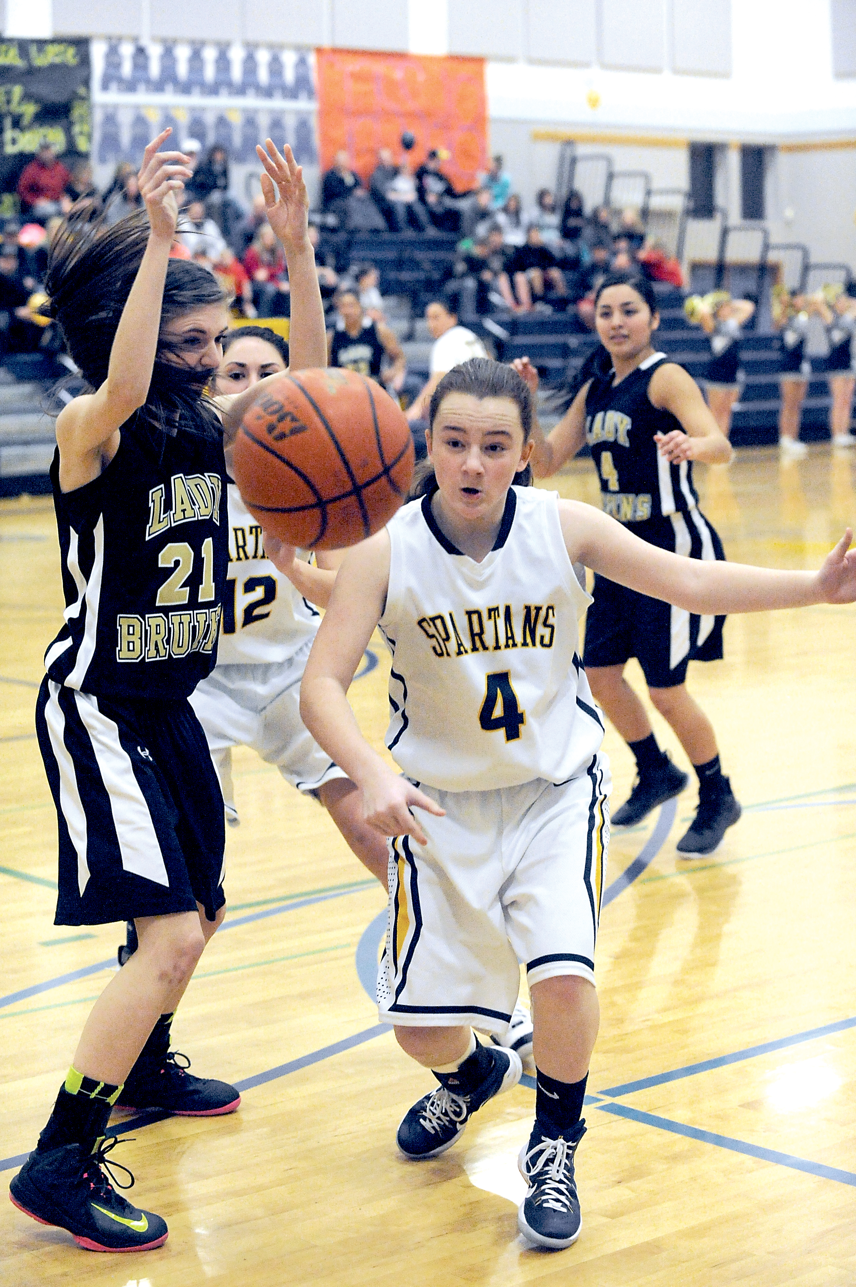 Forks' Skyler DeMatties (4) goes for a loose ball while being defended by Clallam Bay's Jennica Maines (21).  Also in on the action is Forks' Amber Hoagland (12) and Clallam Bay's Mariah LaChester (4). (Lonnie Archibald/for Peninsula Daily News)
