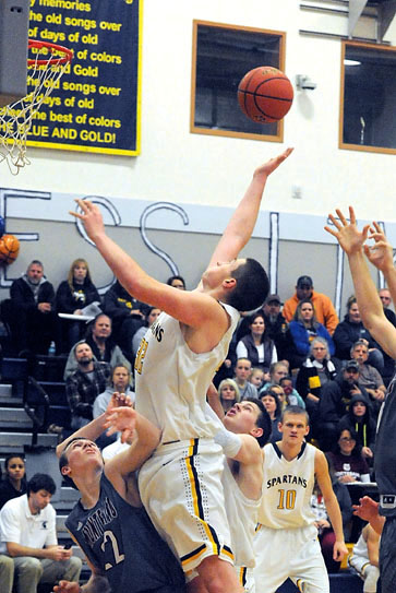 Forks' Marky Adams rebounds over Montesano's Nick Chapman.  Also in on the play is Montesano's Kaleb Chastain and Parker Browning. (Lonnie Archibald/for Peninsula Daily News)