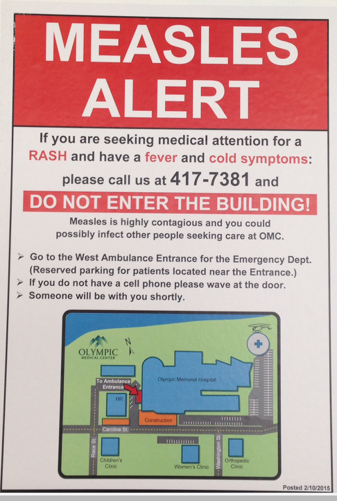 Poster at the entrance to Olympic Medical Center in Port Angeles.  An isolation tent is in a hospital parking lot. ()