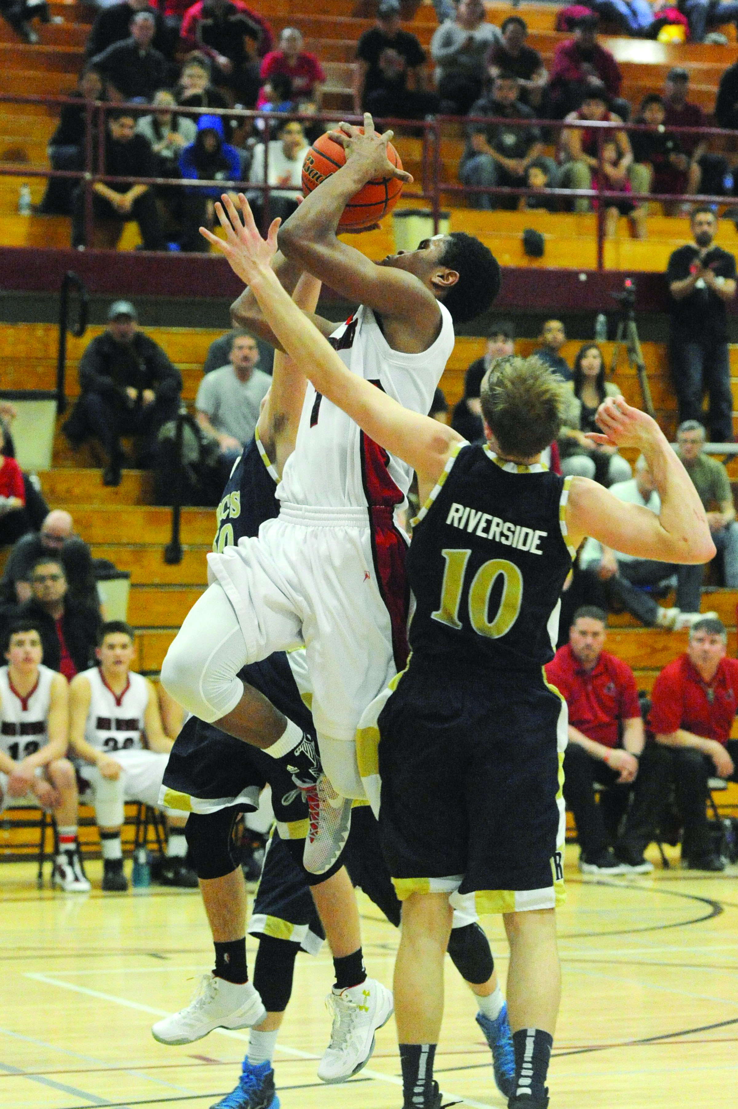 Neah Bay's Rwehabura Munyagi Jr. (1) shoots between Riverside Christian's Tyler Hoffman (10) and Joey Catton during a Class 1B basketball regional round game at W.F. West High School in Chehalis. (Lonnie Archibald/for Peninsula Daily News)