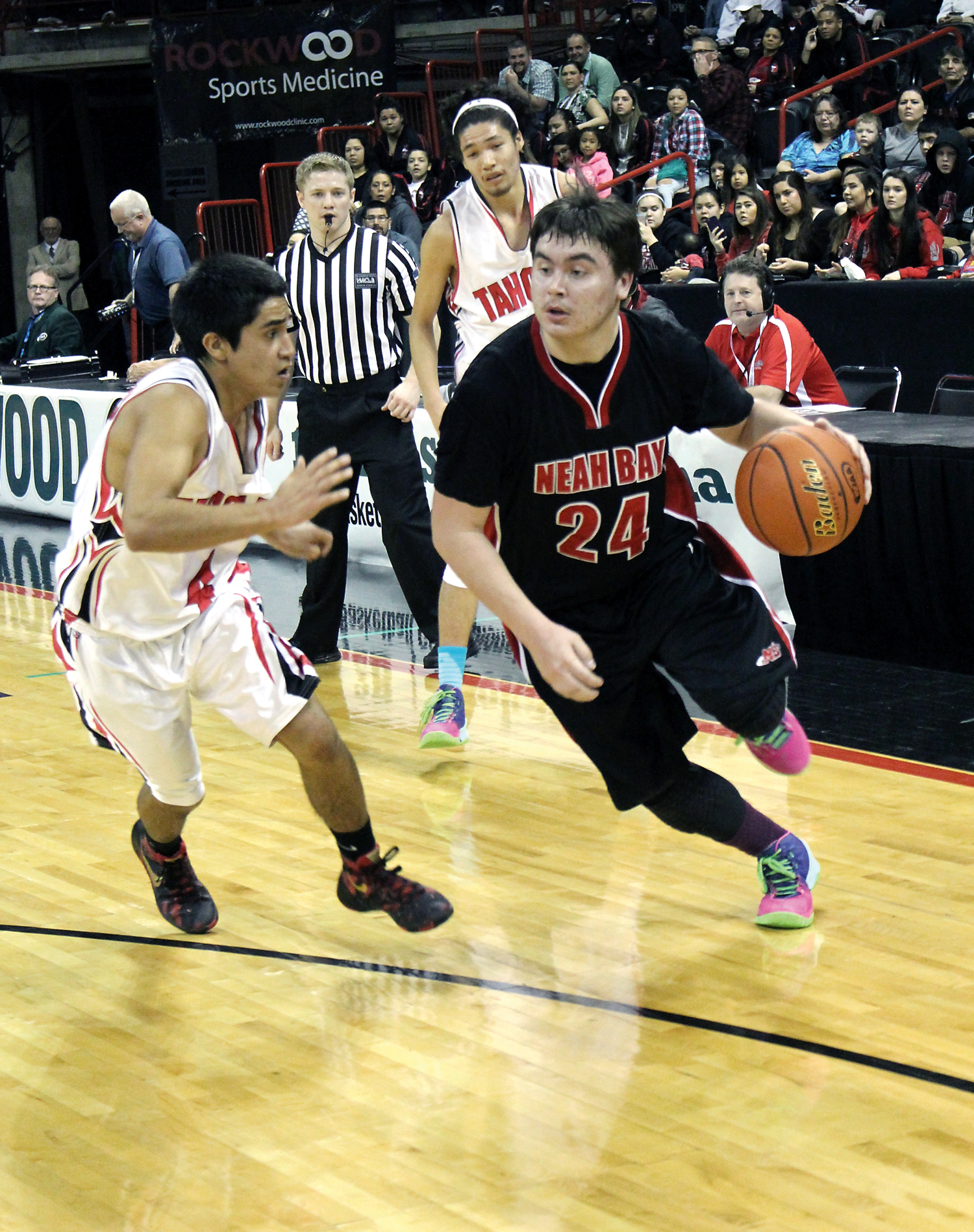 Neah Bay senior Ryan Moss drives the baseline against Taholah junior Brett Orozco during the second quarter of Thursday's 1B state tournament contest. (Roger Harnack/The Daily Sun News)