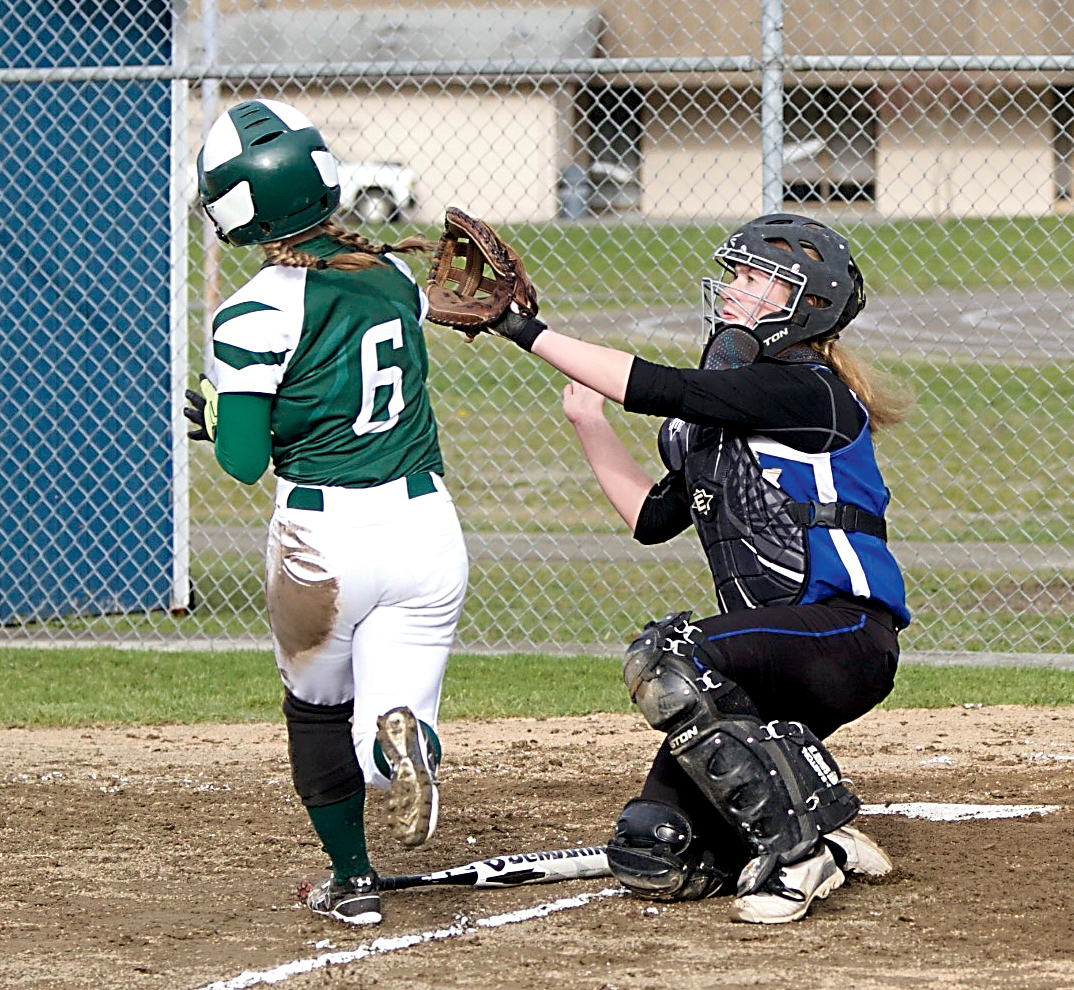 Port Angeles' Sierra Robinson beats the throw home to score in front of Chimacum's Mechelle Nisbet. (Steve Mullensky/for Peninsula Daily News)
