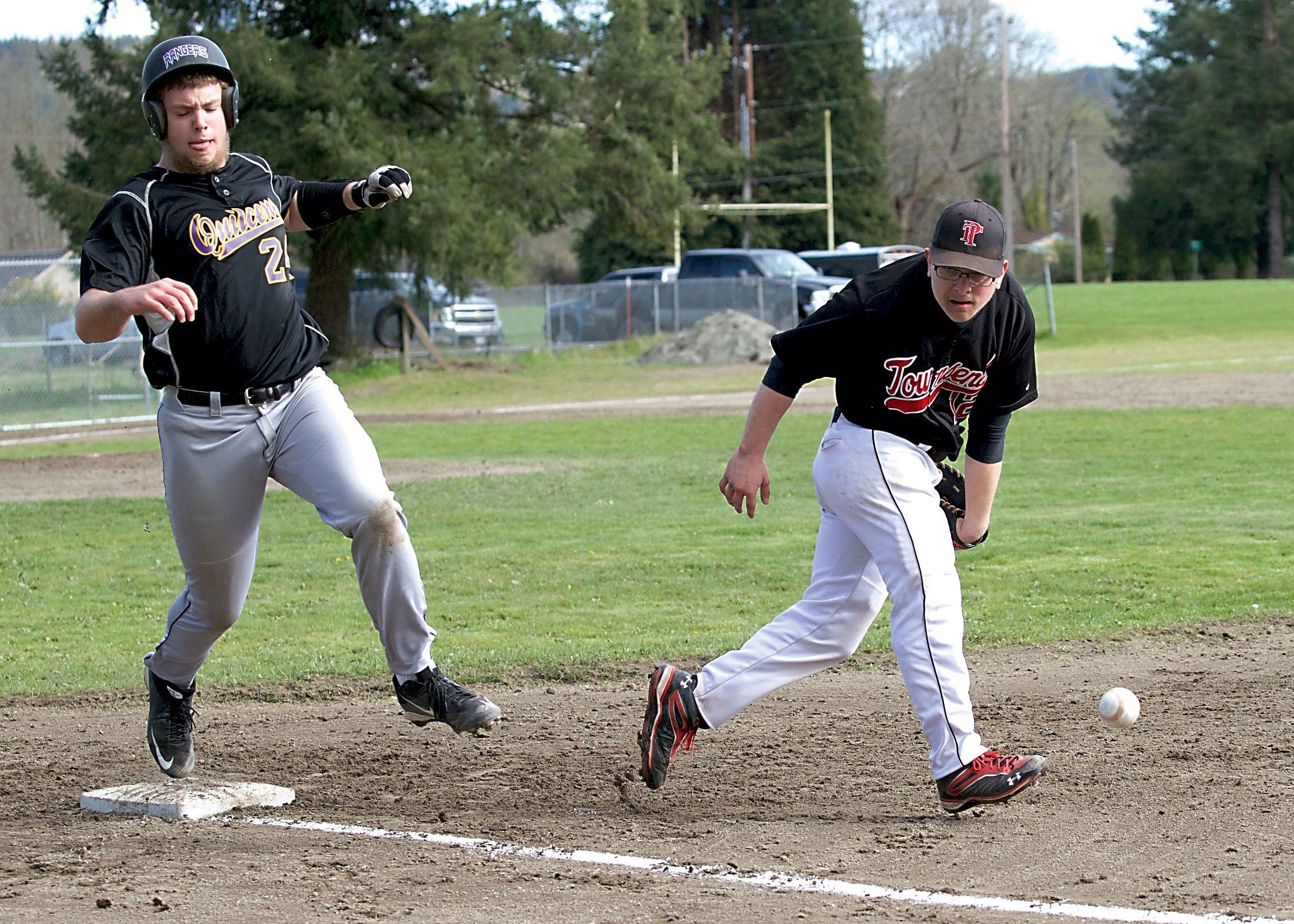 Quilcene's Nathan Weller reaches first base safely as the ball gets by Port Townsend first baseman Cody Morgan-Erfle. (Steve Mullensky/for Peninsula Daily News)