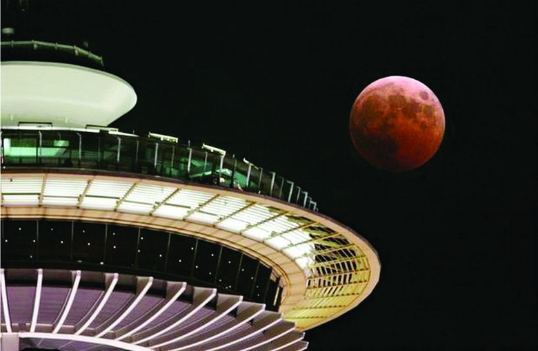 The full moon turns red and orange as it passes the Space Needle in Seattle during a total lunar eclipse Oct. 27