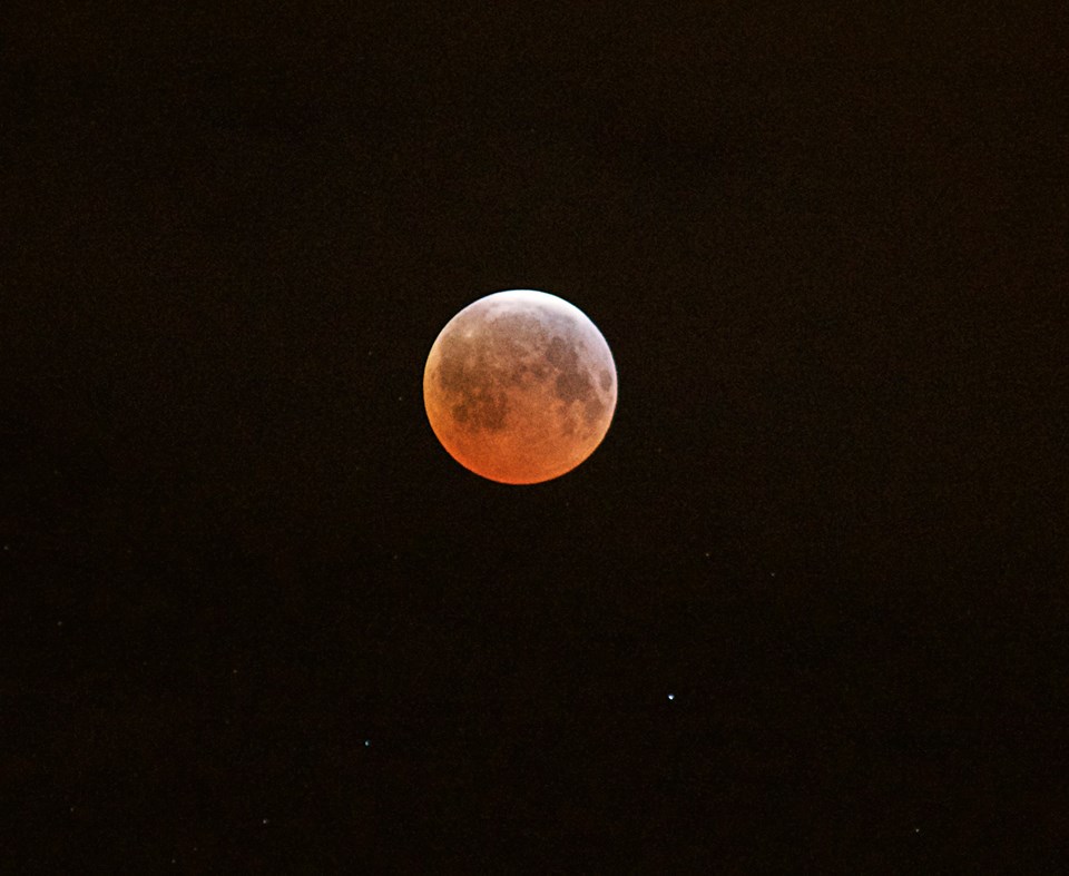 The full moon turns red and orange over Port Angeles this morning. The total lunar eclipse was the third in a series of four “blood moons.” (Jay Cline (click on photo to enlarge))