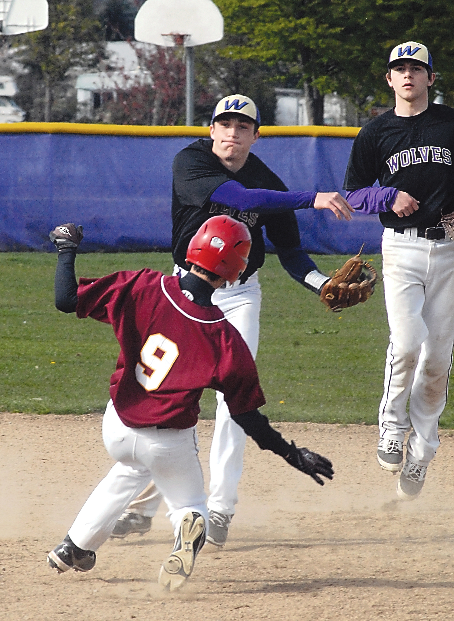 Sequim shortstop Evan Hurn throws to first after cutting off Kingston's Ben Pouliat at second. Sequim second baseman Gavin Velarde