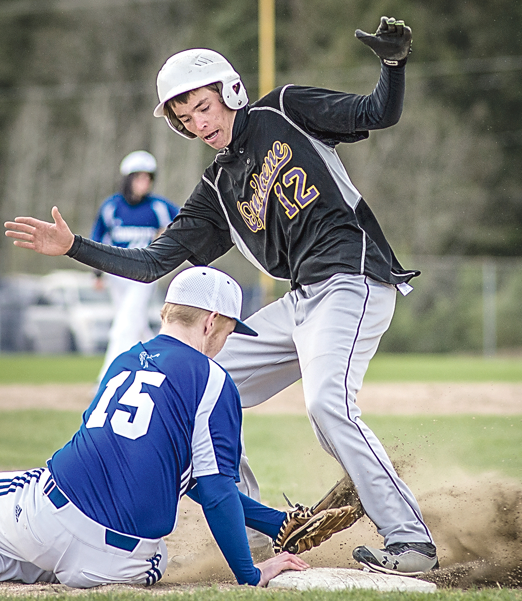 Quilcene base runner Trevor Barnston (12) avoids the tag of Chimacum's Brandon Lingle. (George Leinonen/for Peninsula Daily News)