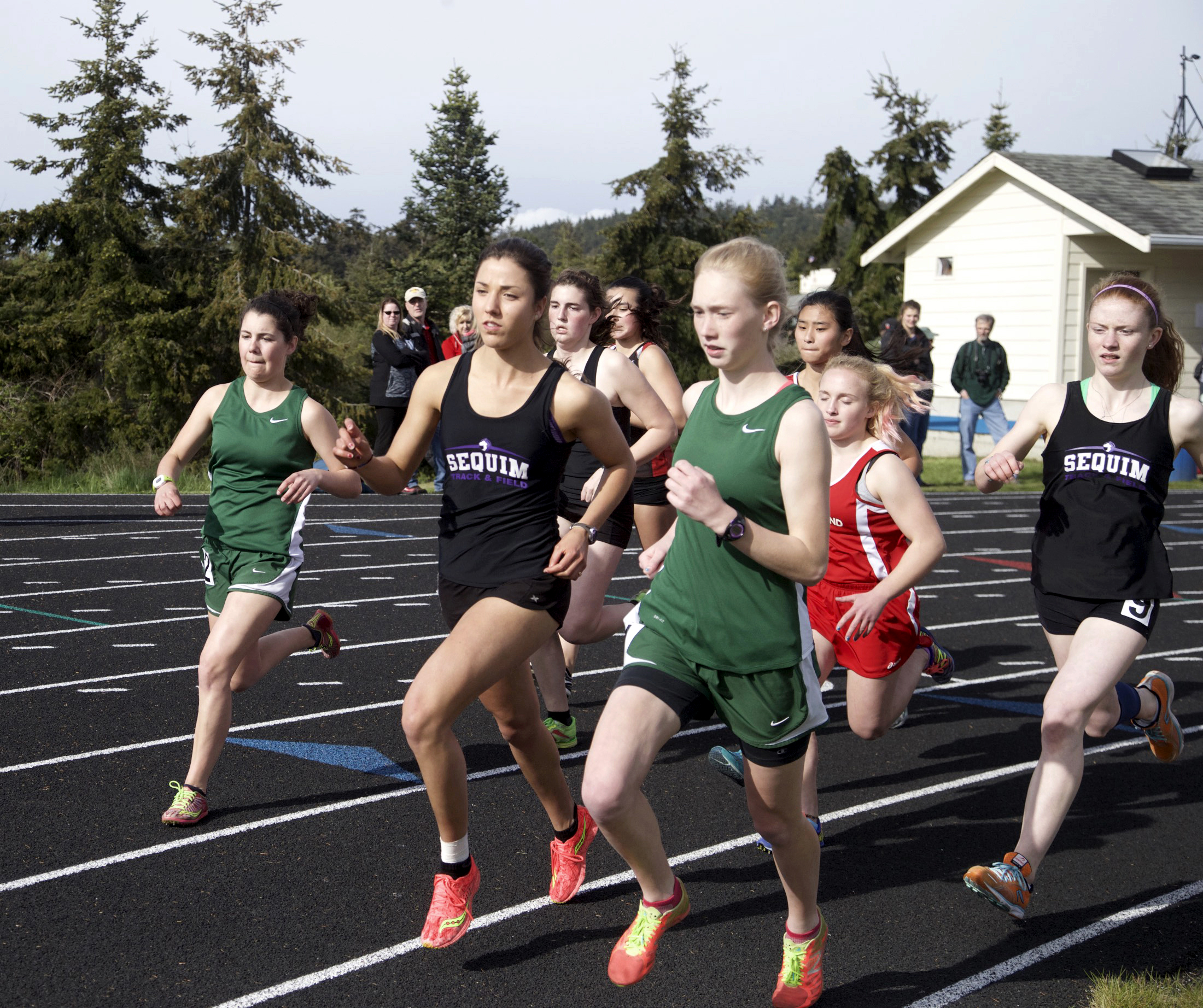 Sequim's Waverly Shreffler and Port Angeles' Gracie Long run side by side at the start of the girls 1