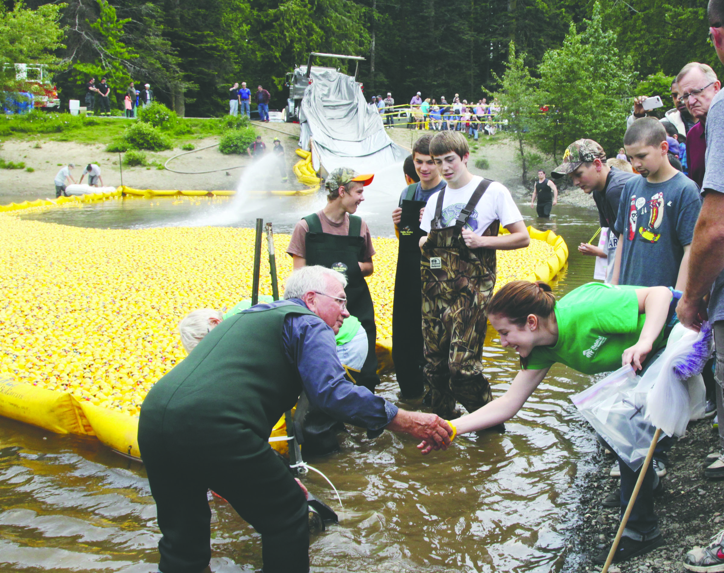 Jerry Hendricks hands off the very first and winning duck to Naomi Kuykendall of Port Angeles at the 2015 Duck Derby. (Dave Logan/for Peninsula Daily News)