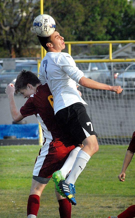 Sequim's Thomas Winfield goes up and over Kingston's Brady Vernik for a header during the first half of the Wolves' 2-0 loss at Sequim High School. (Keith Thorpe/Peninsula Daily News)