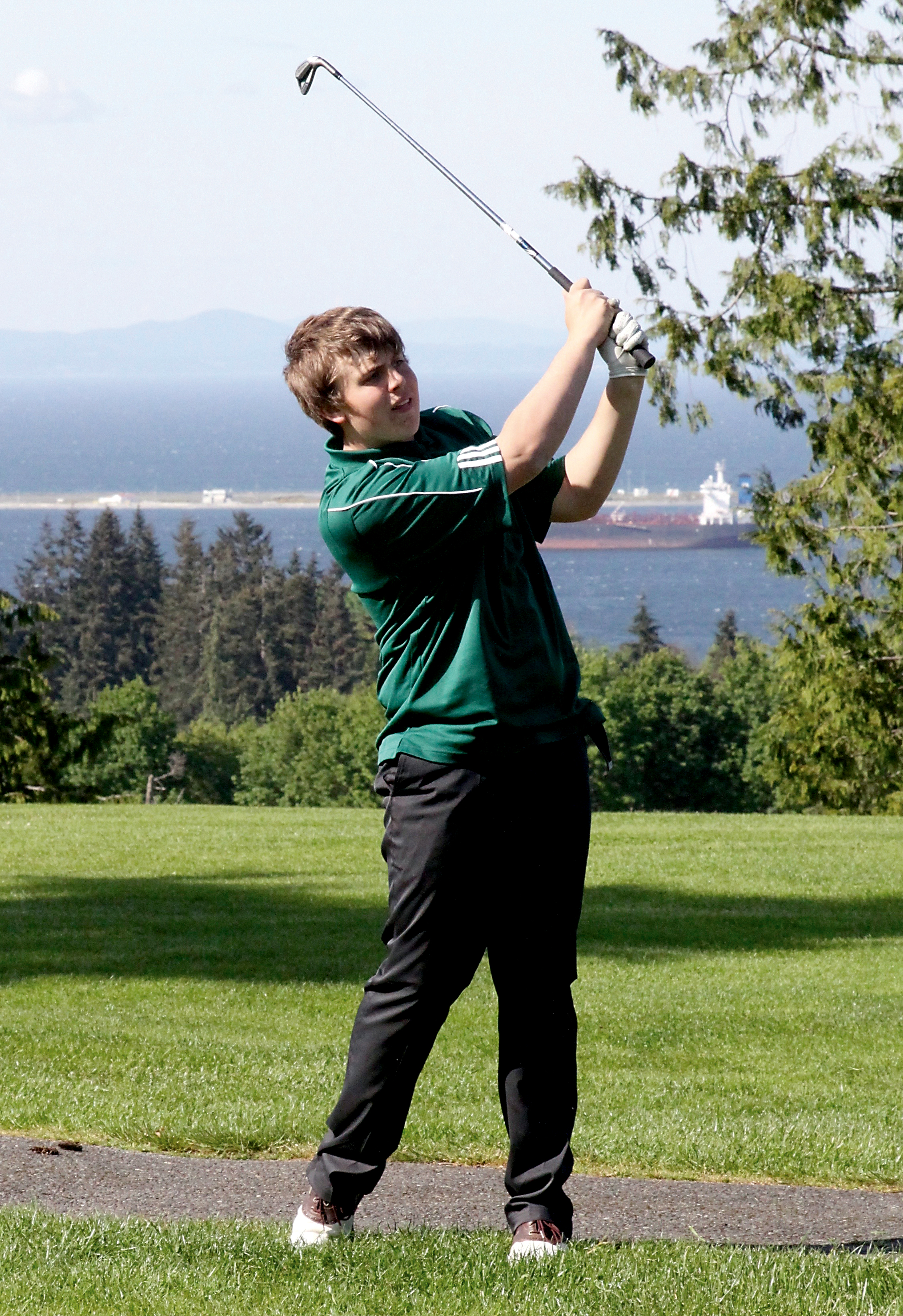 Logan Kovalenko of Port Angeles follows through on the 13th fairway at Peninsula Golf Course. (Dave Logan/for Peninsula Daily News)