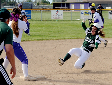 Port Angeles' Sierra Robinson (6) reaches third base safely as Sequim's Chloie Sparks awaits the throw and Port Angeles coach Randy Steinman