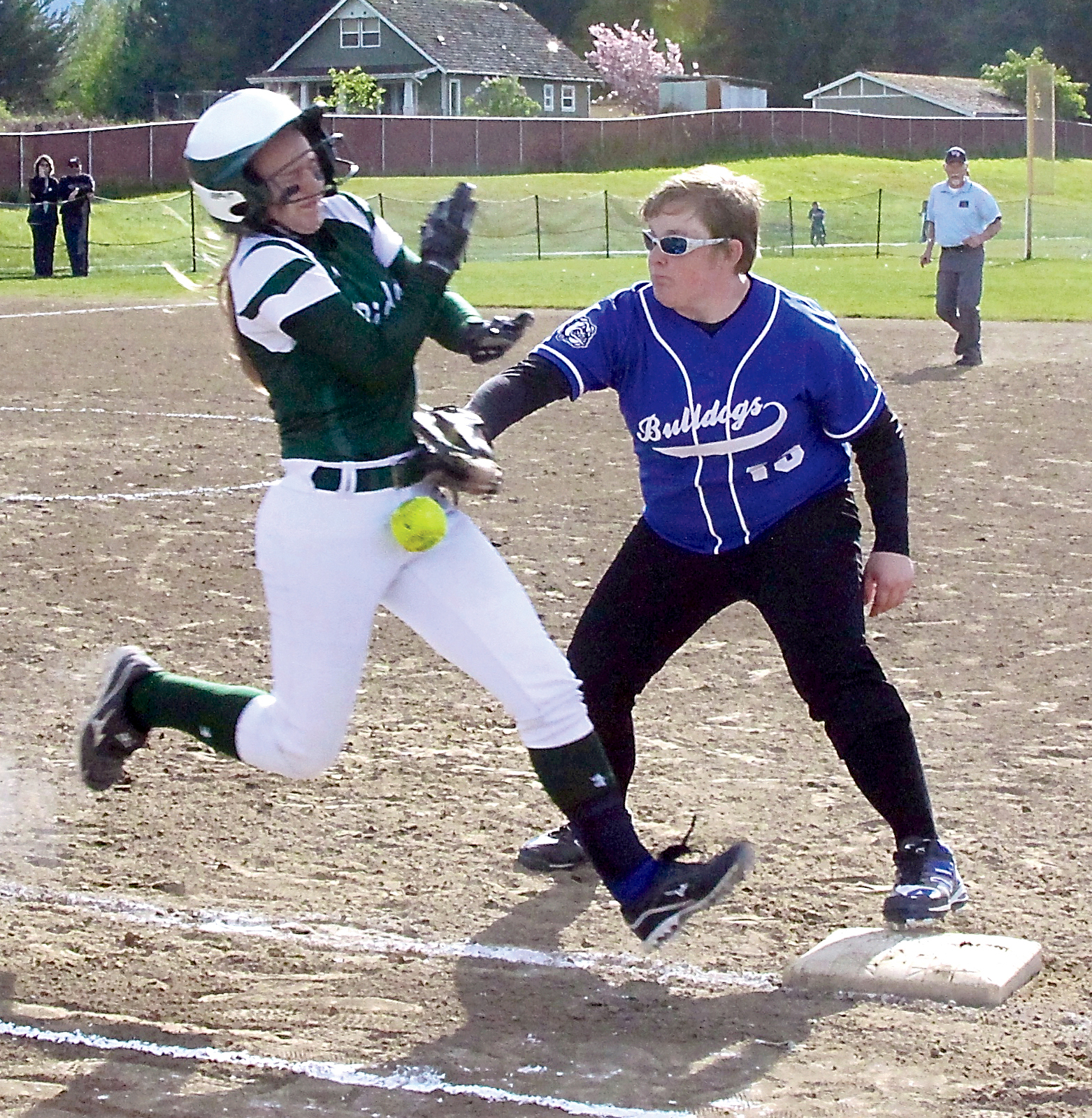 Port Angeles' Kylee Reid knocks the ball out of the glove of North Mason first baseman Rylie Mullins to arrive safely at first base. (Dave Logan/for Peninsula Daily News)