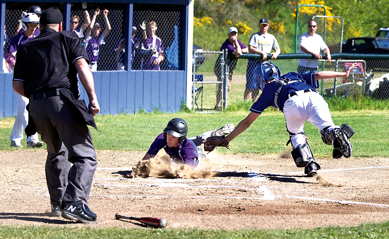 Quilcene's A.J. Prater dives for home but was tagged out by Seattle Lutheran catcher Eli Clark in the first inning of a district playoff game played at Bob Bates Little League Fields in Port Hadlock on Tuesday. (Steve Mullensky/for Peninsula Daily News)