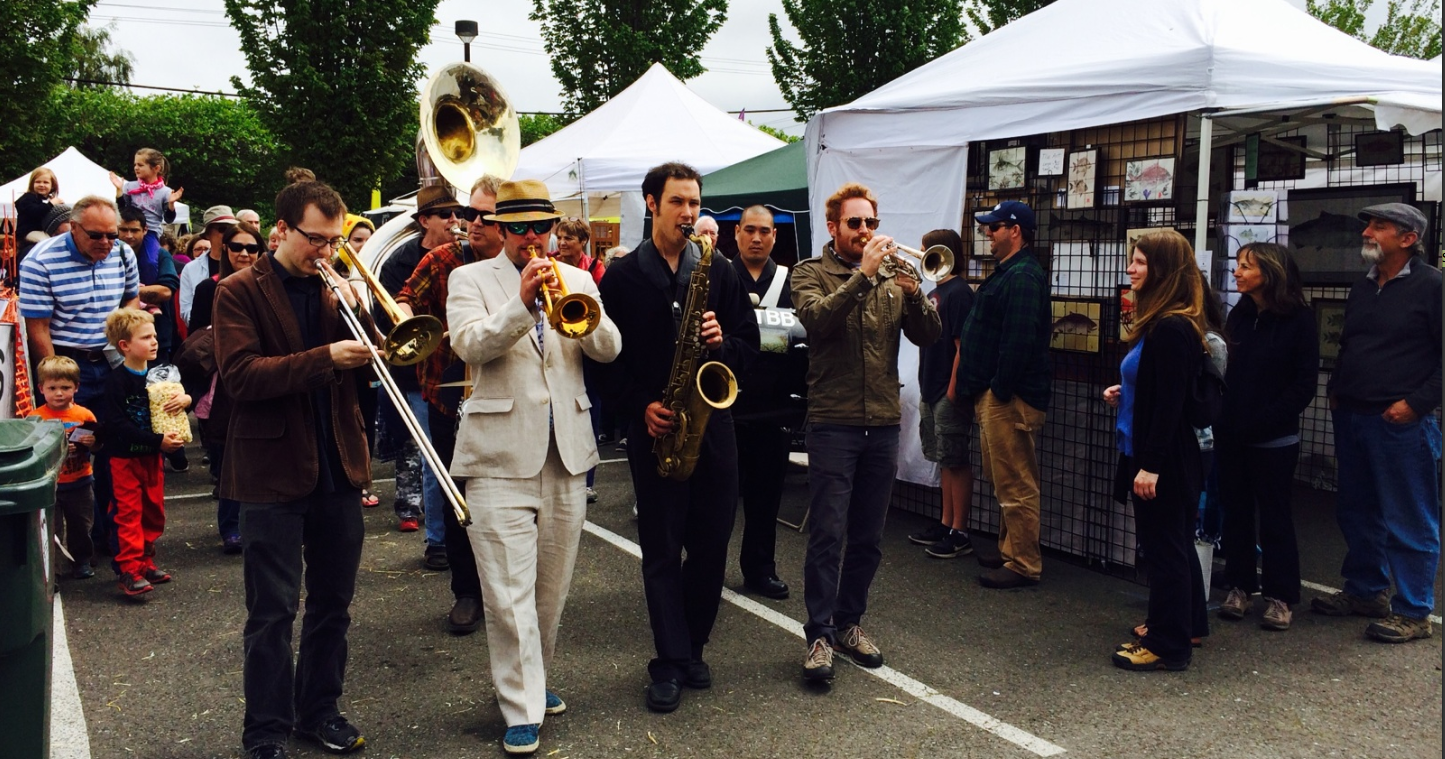 Transcendental Brass Band members make their way through vendors at the Juan de Fuca Festival before their  performance Saturday. (Paul Gottlieb/Peninsula Daily News (Click on image to enlarge))
