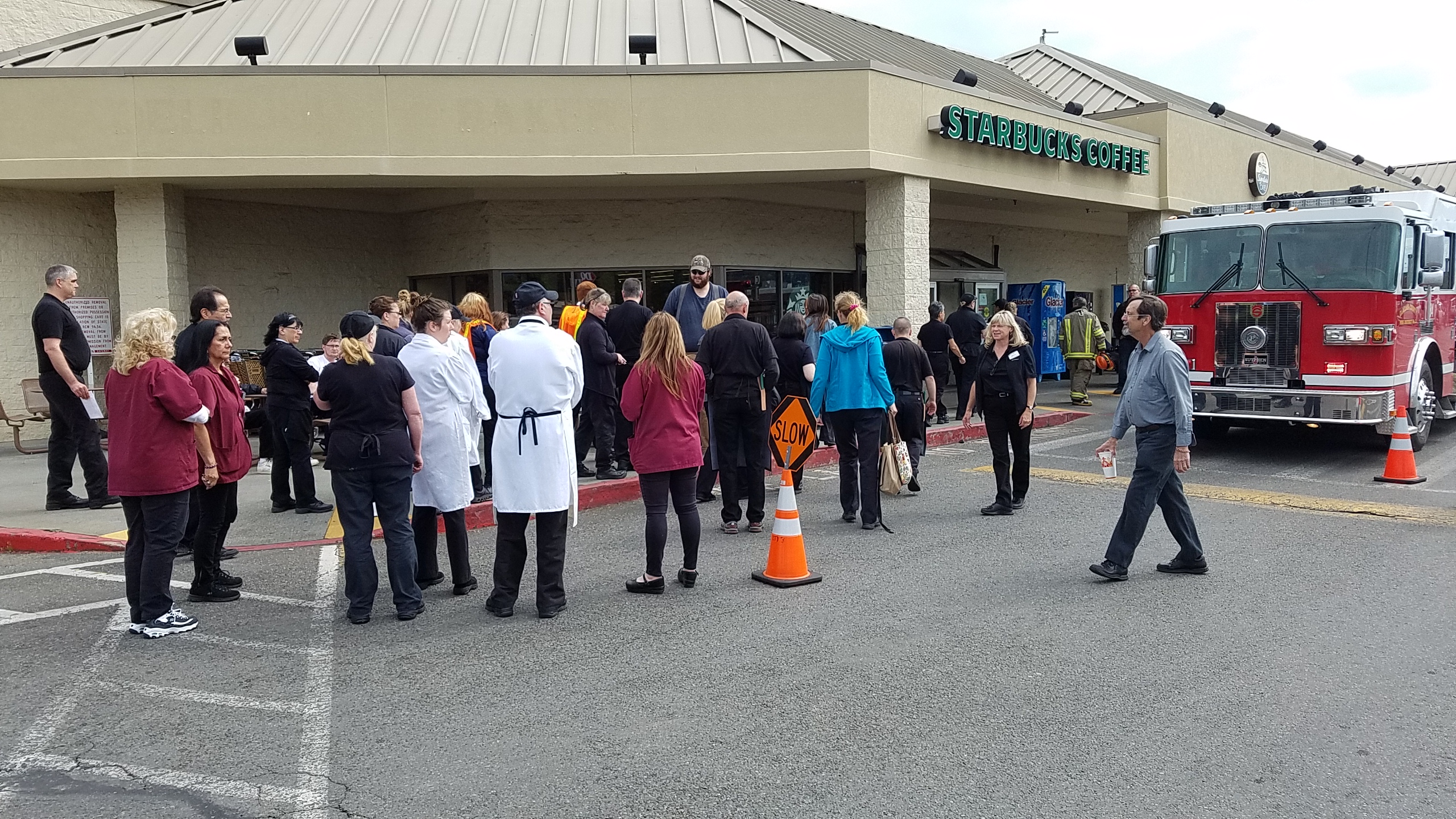 Safeway customers and employees gather outside the store in Sequim after an evacuation for smoke Friday morning (Ed Evans/KSQM)