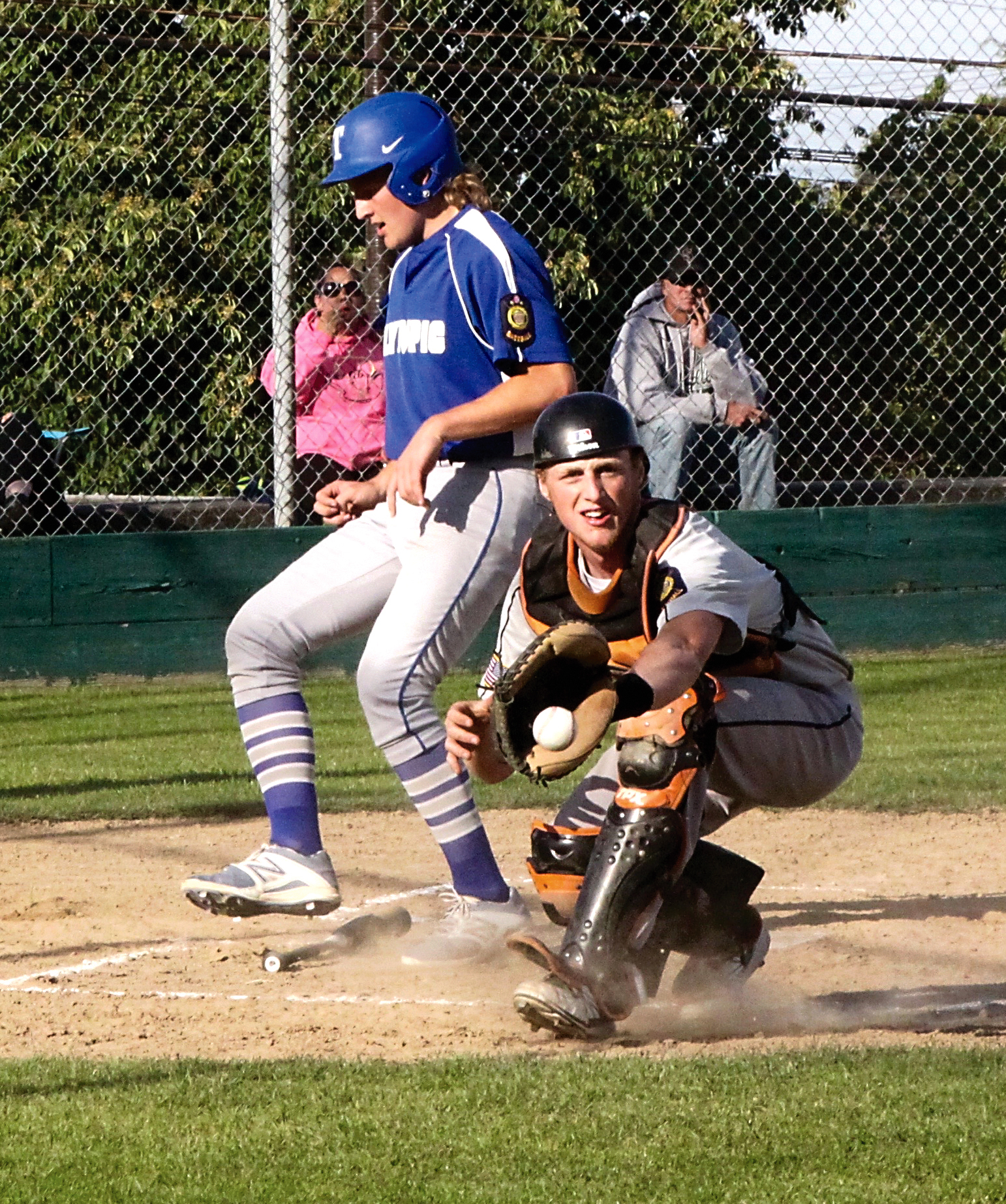 Olympic Crosscutters catcher Tyrus Beckett catches a throw to the plate a little late as Ethan Tufts of the Olympic Tigers scores standing up. (Dave Logan/for Peninsula Daily News)