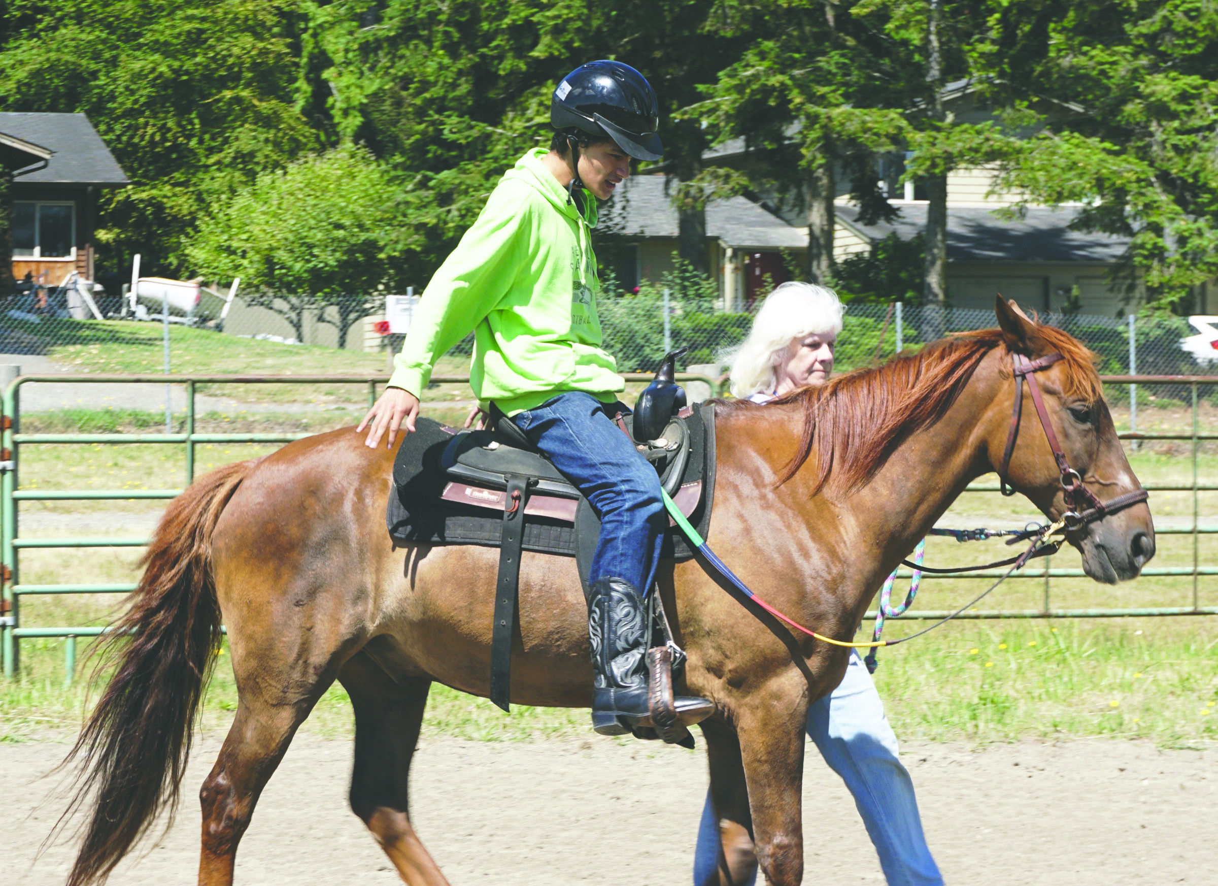 Griffin Bailey of Seattle rides Nevada while volunteer Terry Naughton leads them around the track. Bailey is a participant in the Salish Spirit therapeutic riding program