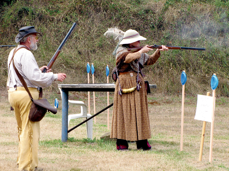 Two historically costumed members of the Green RIver Mountain Men take part in a black powder shoot at the 2014 Green River Mountain Men Rendezvous. Arwyn Rice/Peninsula Daily News