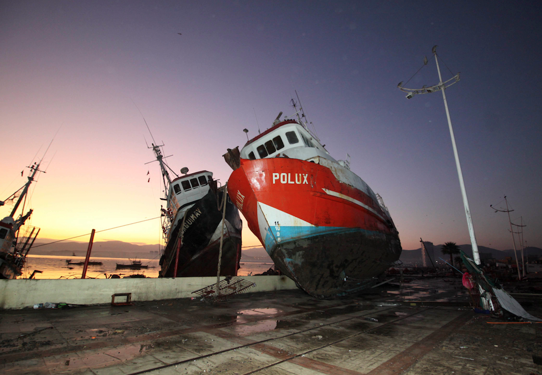 A fishing boat was tossed onto a dock after it was lifted by an earthquake-triggered tsunami in Coquimbo