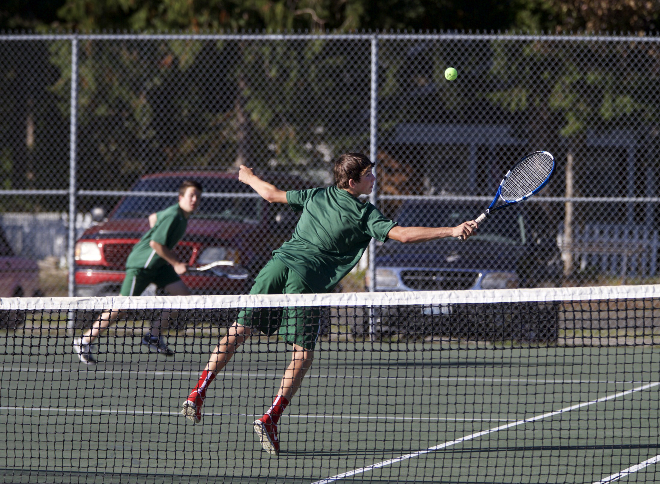 Port Angeles' Kenny Soule attempts a behind-the-back volley as doubles partner Zach Smith runs to back up the play during a match against Chimacum-Port Townsend at Chimacum High School on Monday. Steve Mullensky/for Peninsula Daily News