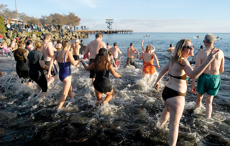 Polar bear dippers rush into the chilly waters of Port Angeles Harbor at Hollywood Beach in last year's plunge. (Keith Thorpe/Peninsula Daily News)