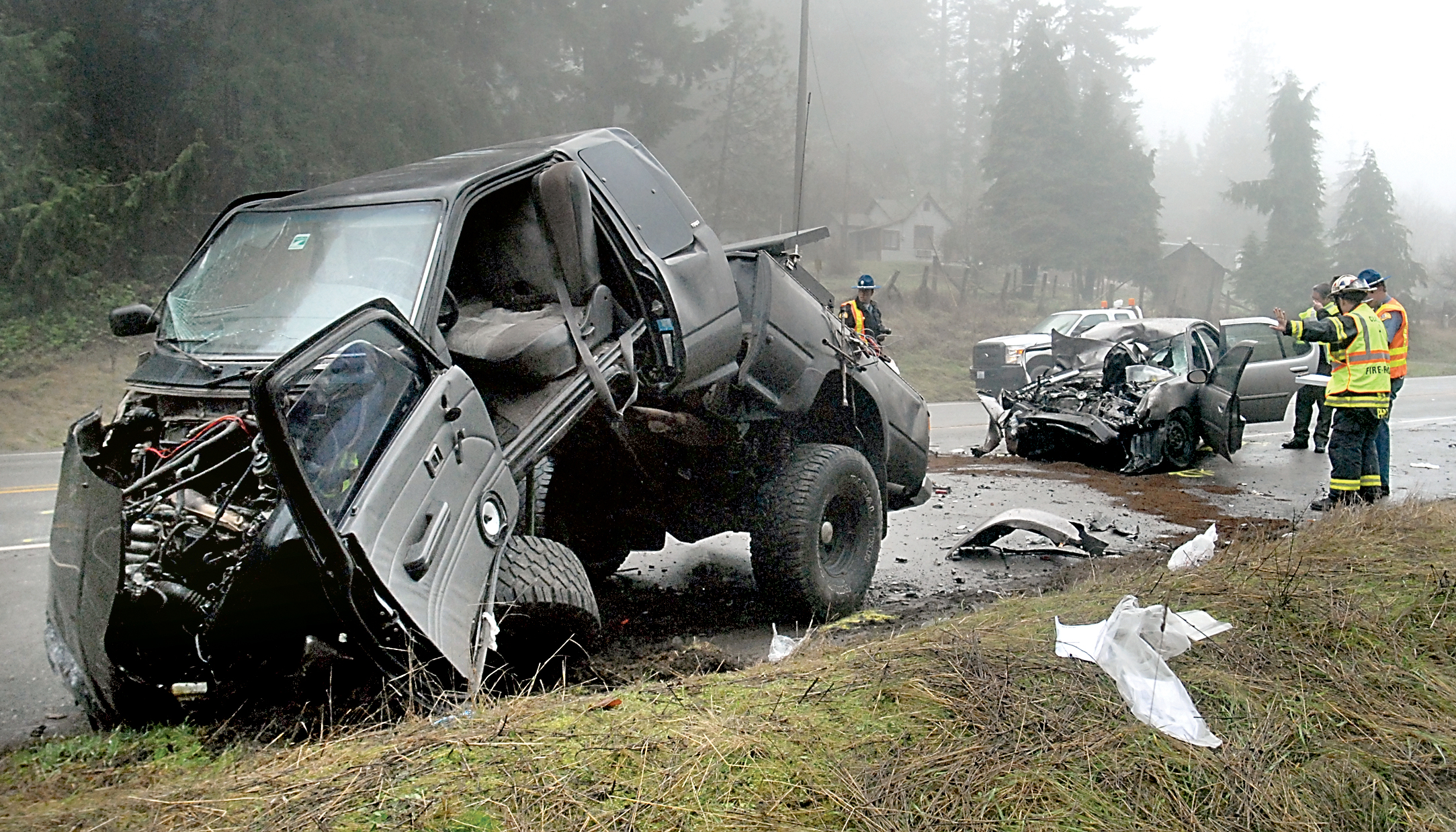 Law enforcement and rescue personnel survey the scene of a two-vehicle head-on collision on U.S. 101 east of Laird Road near Port Angeles on Wednesday.  —Photo by Keith Thorpe/Peninsula Daily News ()